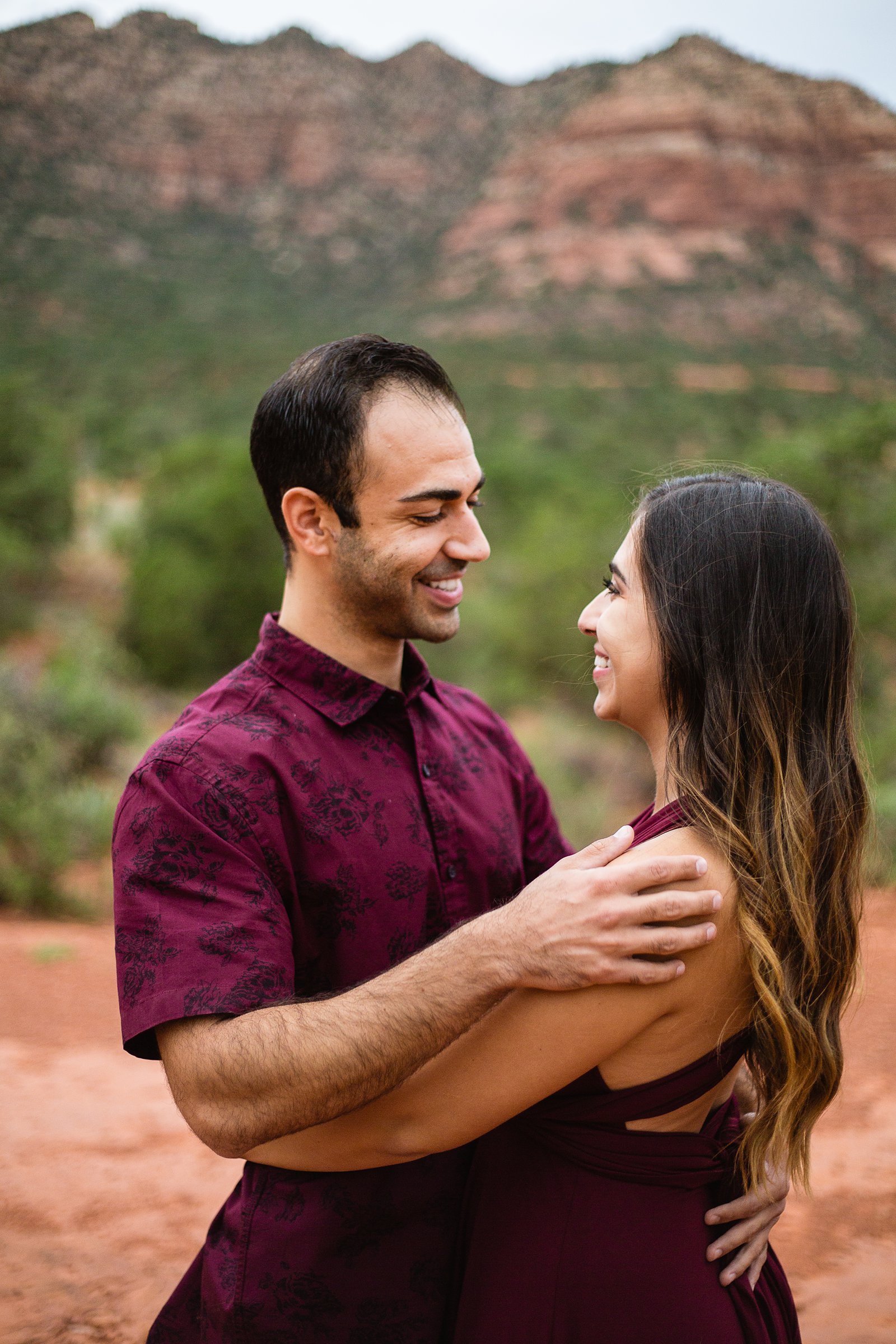 Couple share an intimate moment during their Bell Rock Monsoon engagement session by Sedona engagement photographer PMA Photography.
