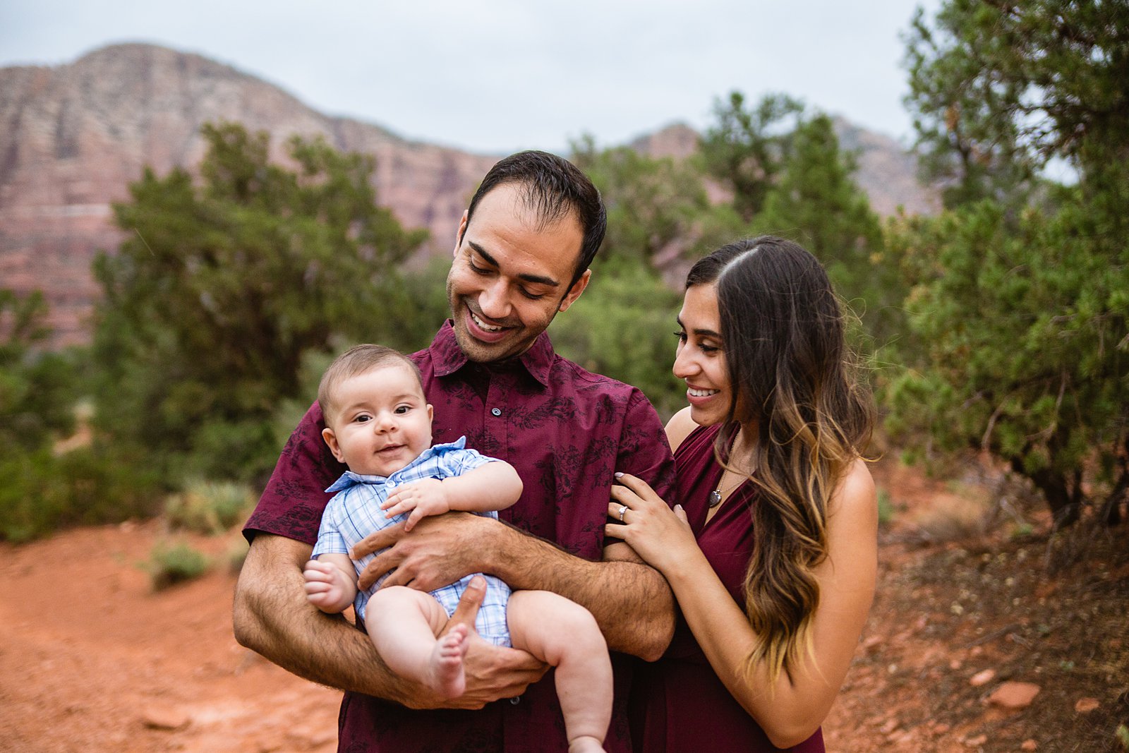 Couple pose together with their baby son during their Sedona engagement session by PMA Photography.