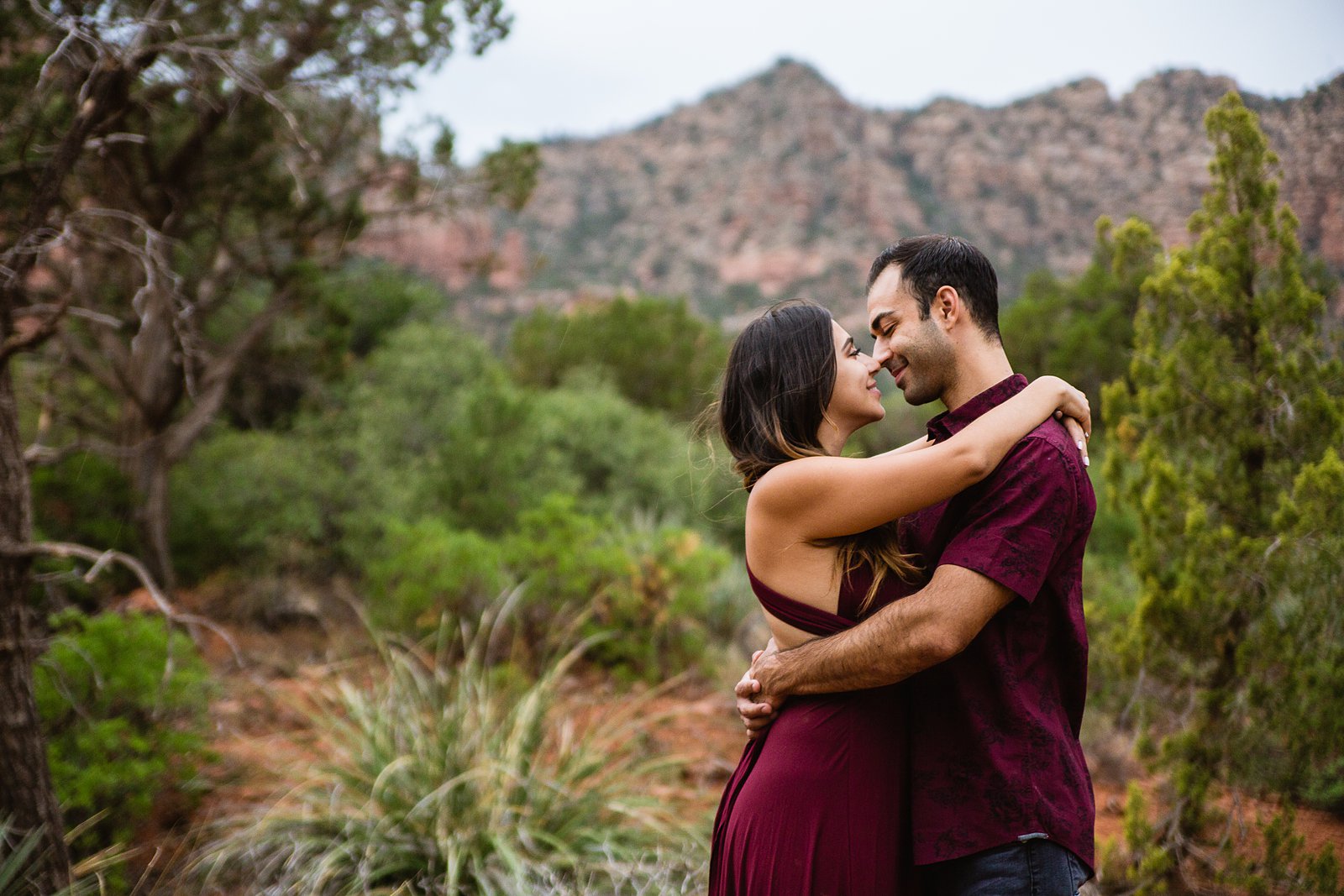 Couple share an intimate moment during their Bell Rock Monsoon engagement session by Sedona engagement photographer PMA Photography.