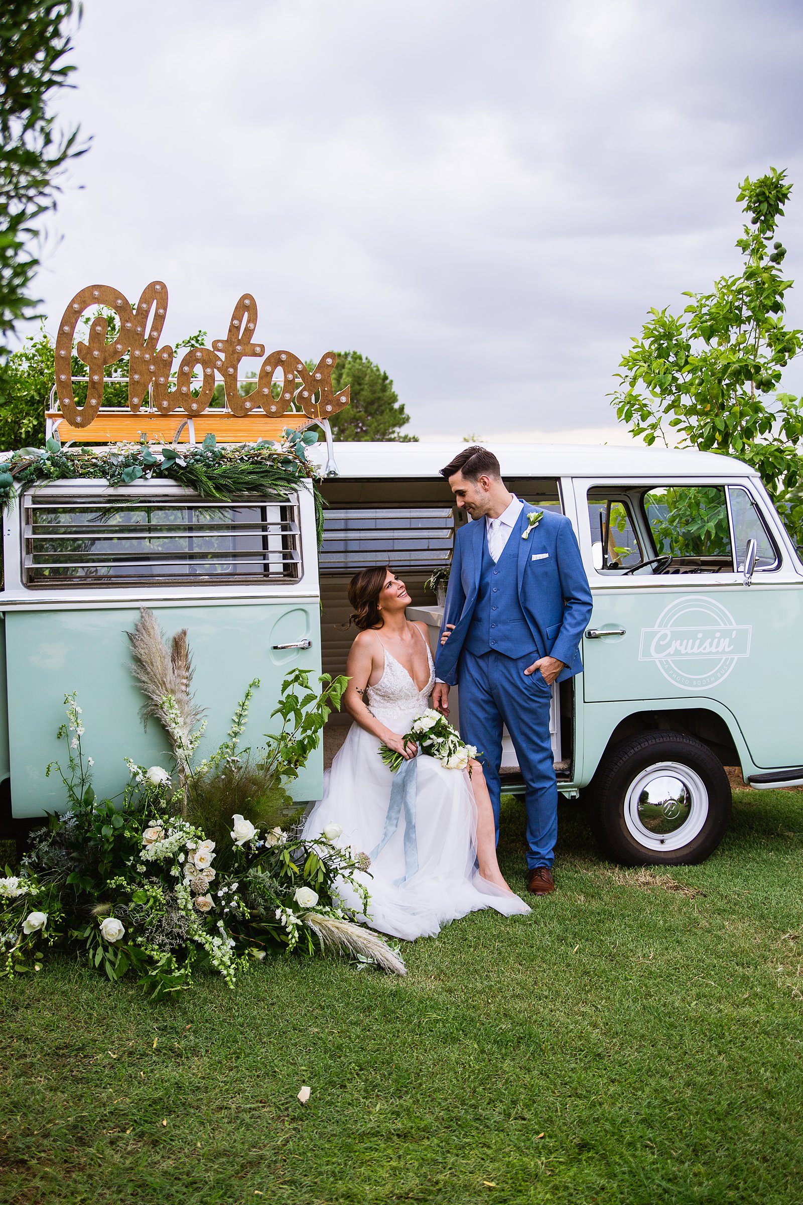 Bride and groom together with VW Cruisin' Photo Booth Bus booth at Gather Estate wedding by Arizona wedding photographers PMA Photography.