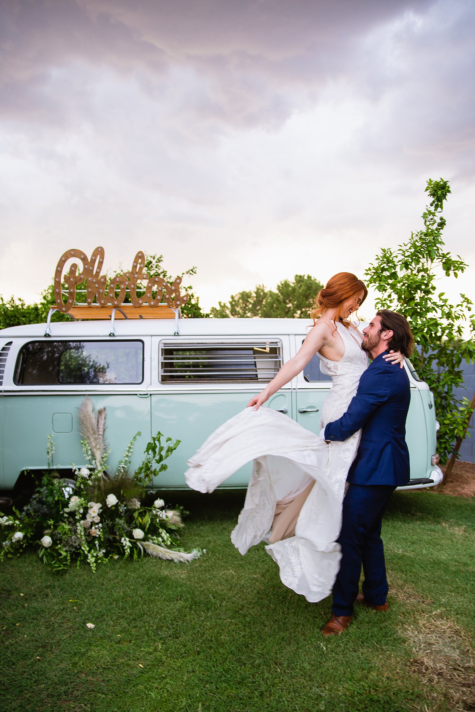 Bride and groom together with VW Bus photo booth at Gather Estate wedding by Arizona wedding photographers PMA Photography.