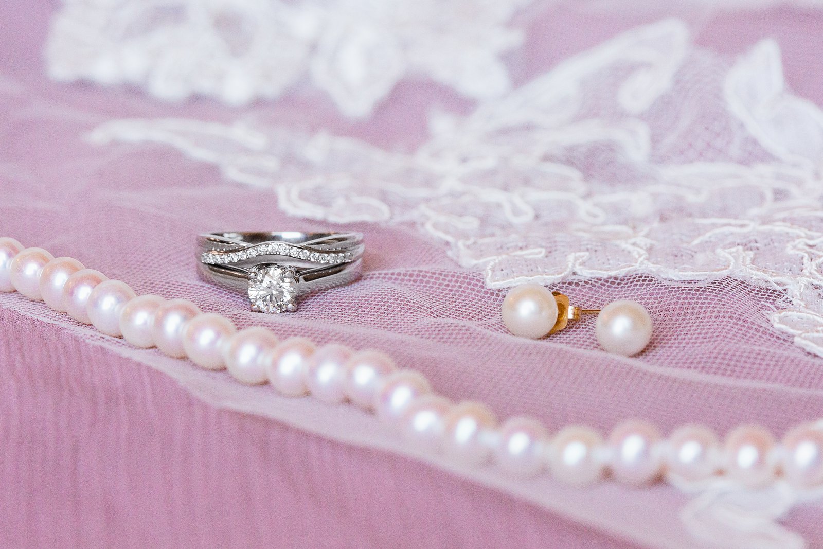 Brides's wedding day details of her wedding ring and pearls on her veil by PMA Photography.