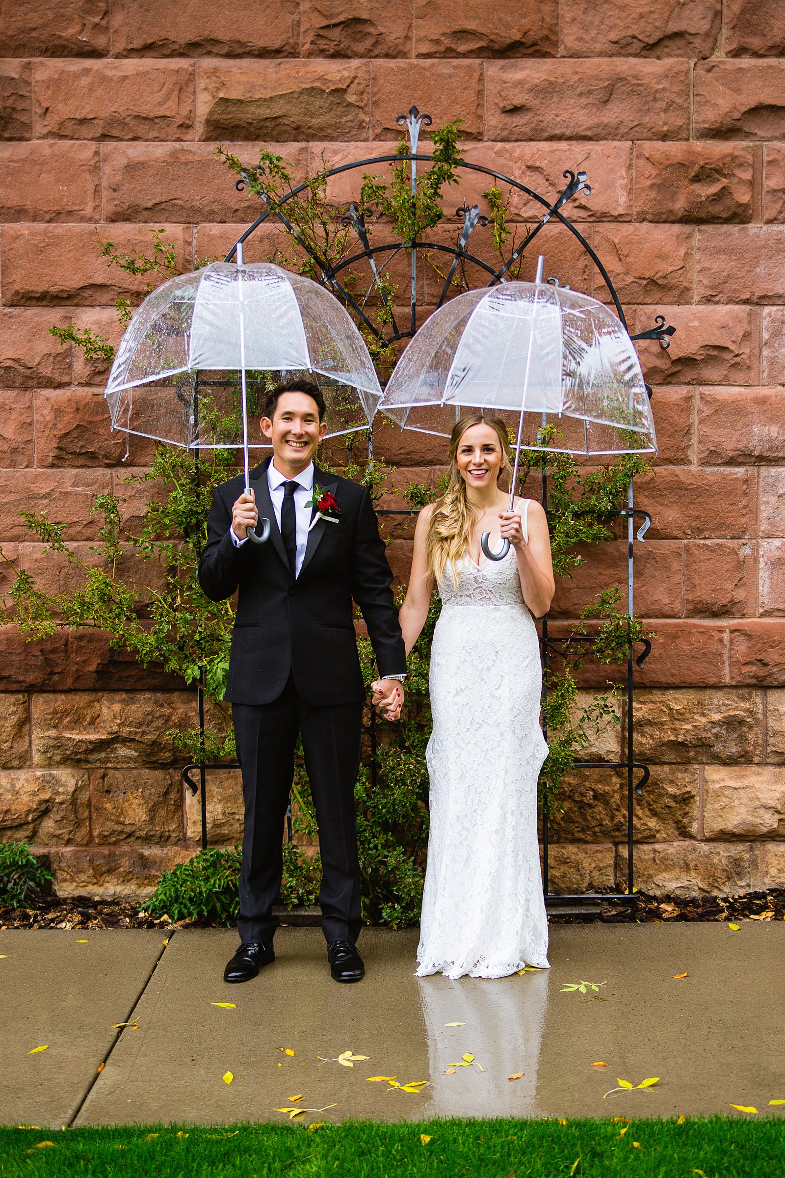 Bride and groom pose for their rainy Flagstaff Courthouse wedding by Flagstaff wedding photographer PMA Photography.