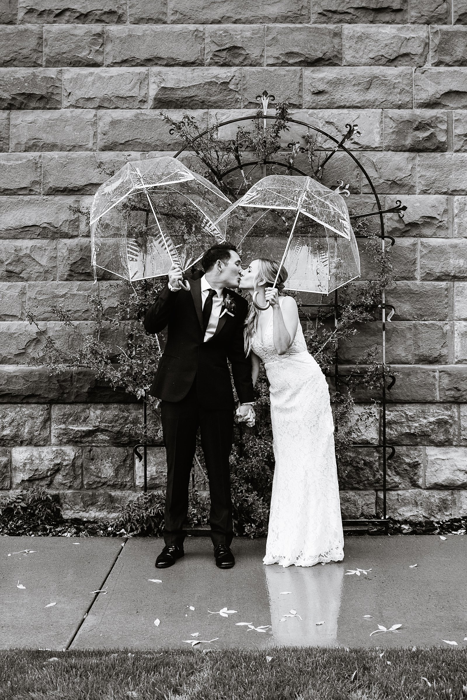 Bride and groom share a kiss during their rainy Flagstaff Courthouse wedding by Arizona wedding photographer PMA Photography.