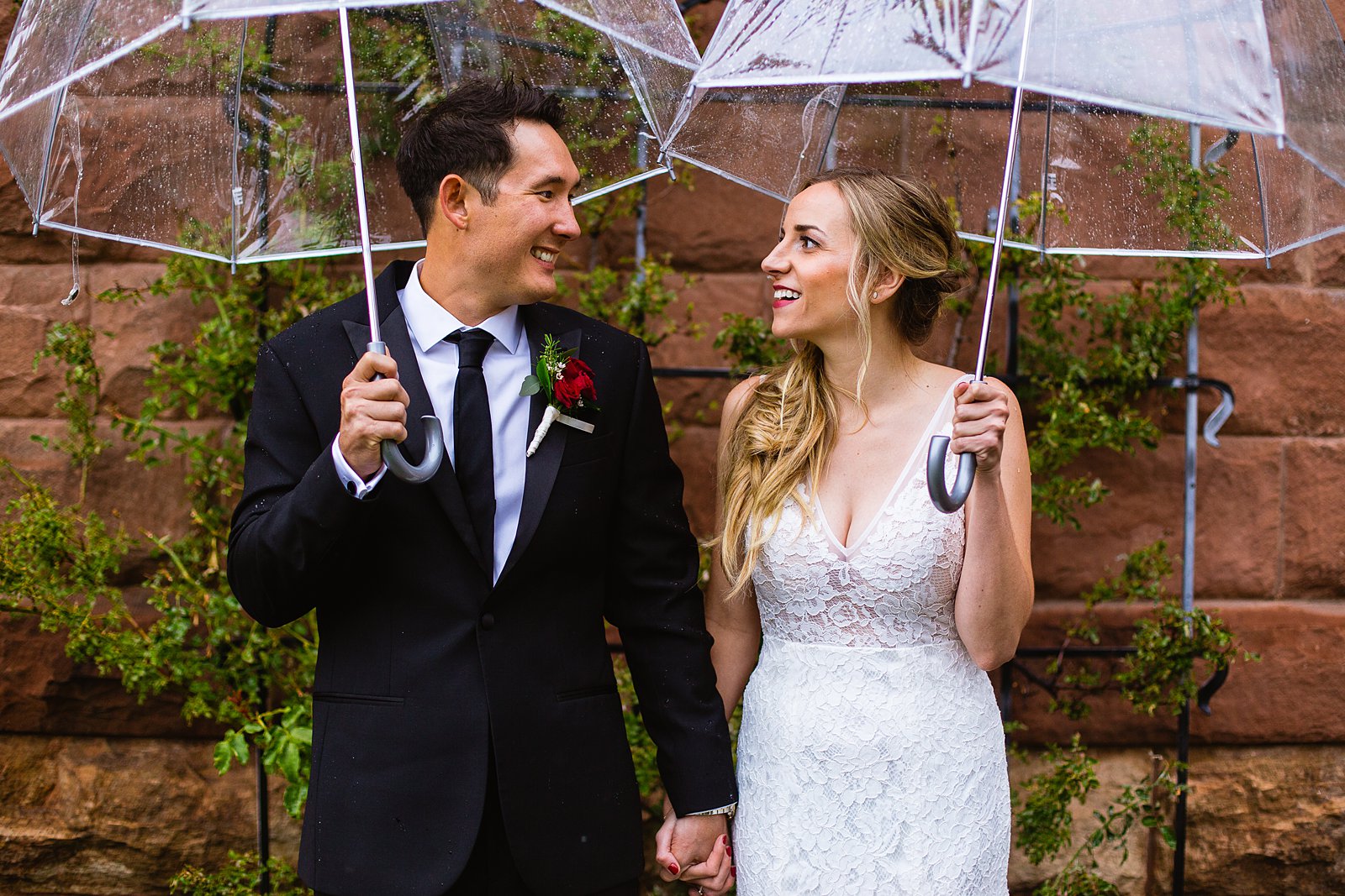 Bride and groom laughing together during their rainy Flagstaff Courthouse wedding by Flagstaff wedding photographer PMA Photography.