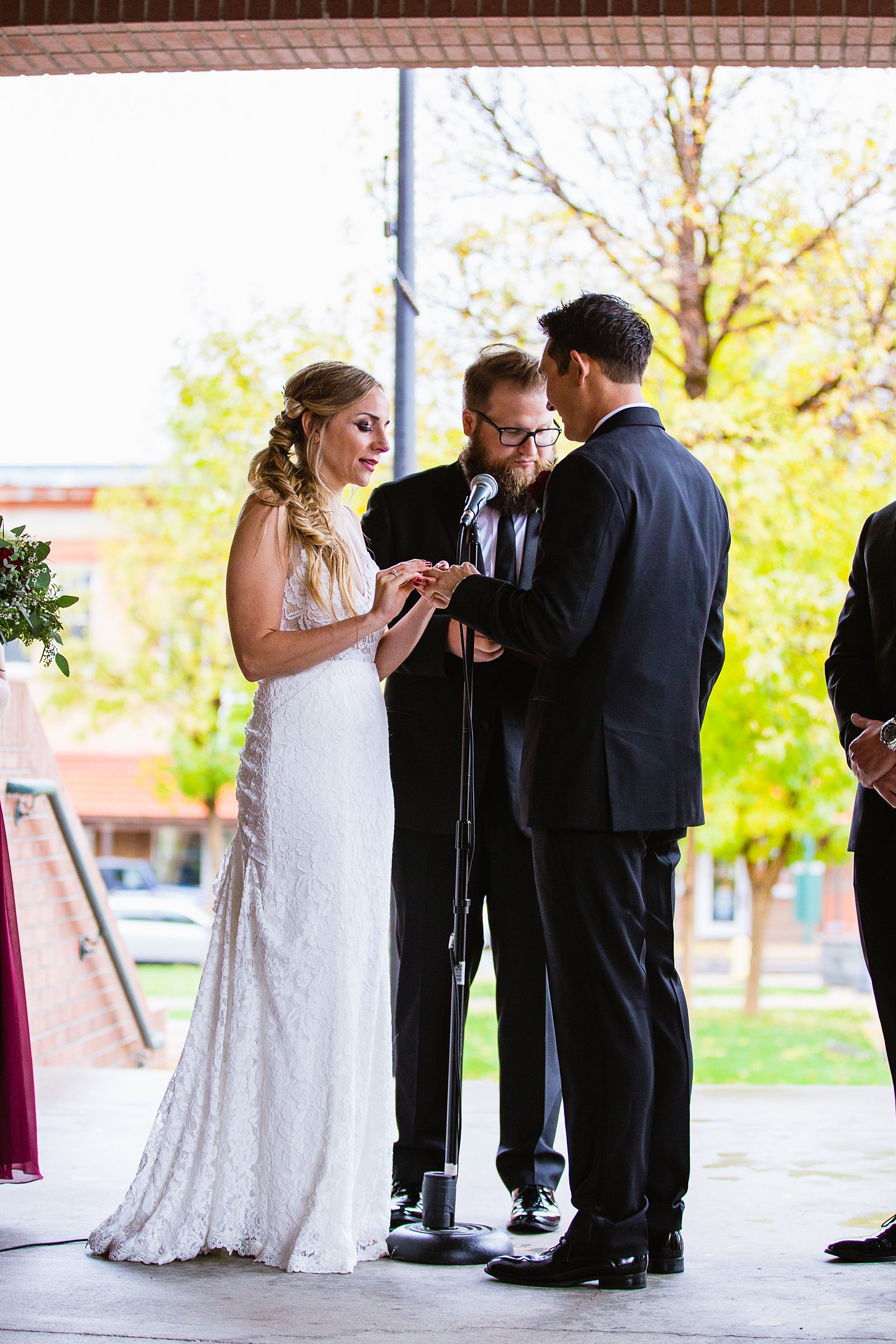 Bride and groom exchange rings during their wedding ceremony at downtown Flagstaff by Arizona wedding photographer PMA Photography.