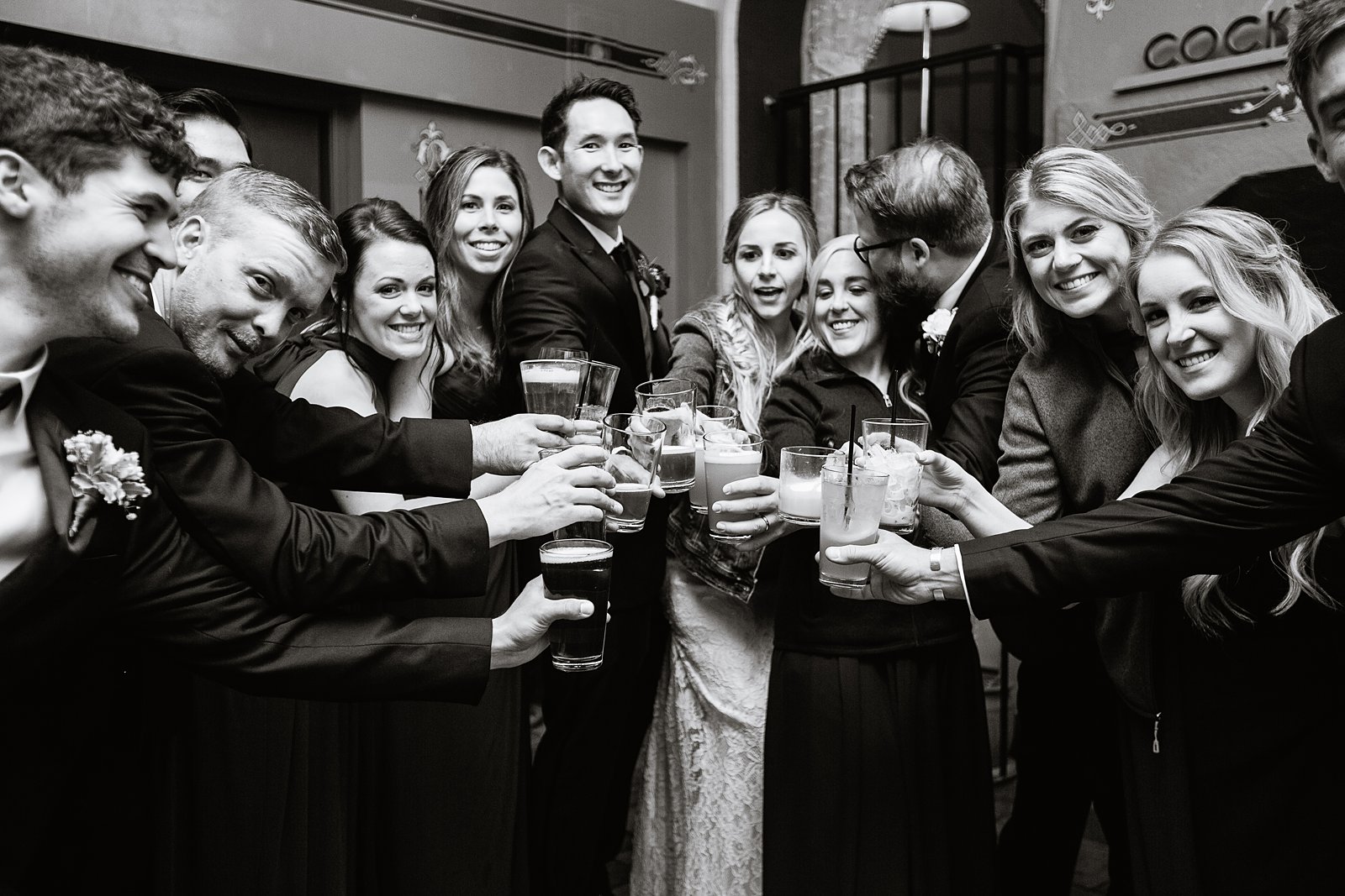 Bride and groom sharing a toast with their bridal party at their favorite Flagstaff bar by Arizona wedding photographer PMA Photography.
