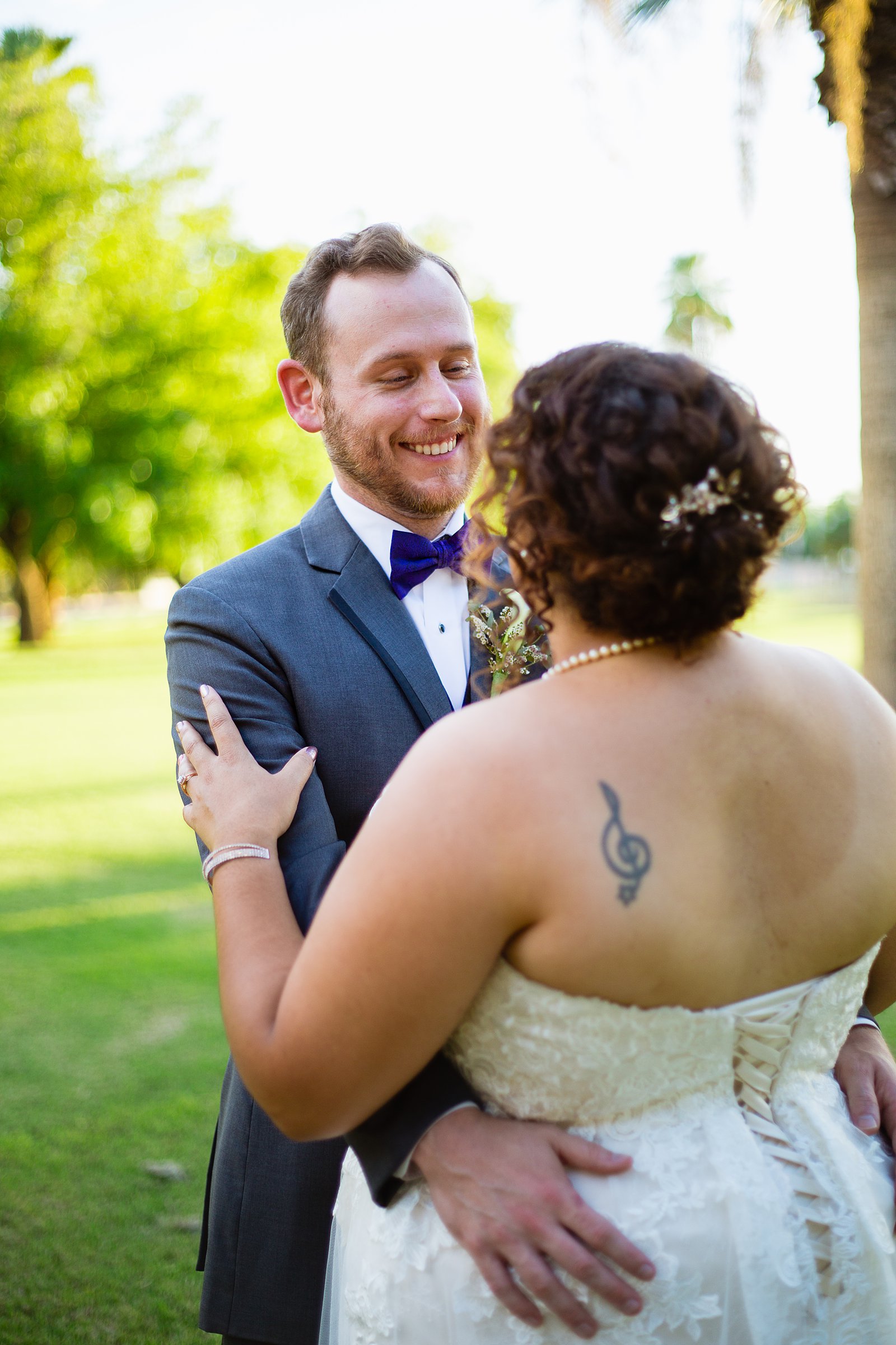 Bride and groom laughing together during their Encanto Park wedding by Arizona wedding photographer PMA Photography.