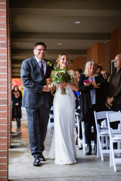 Bride walking down the aisle with her father at a wedding ceremony in downtown Flagstaff by Arizona wedding photographer PMA Photography.