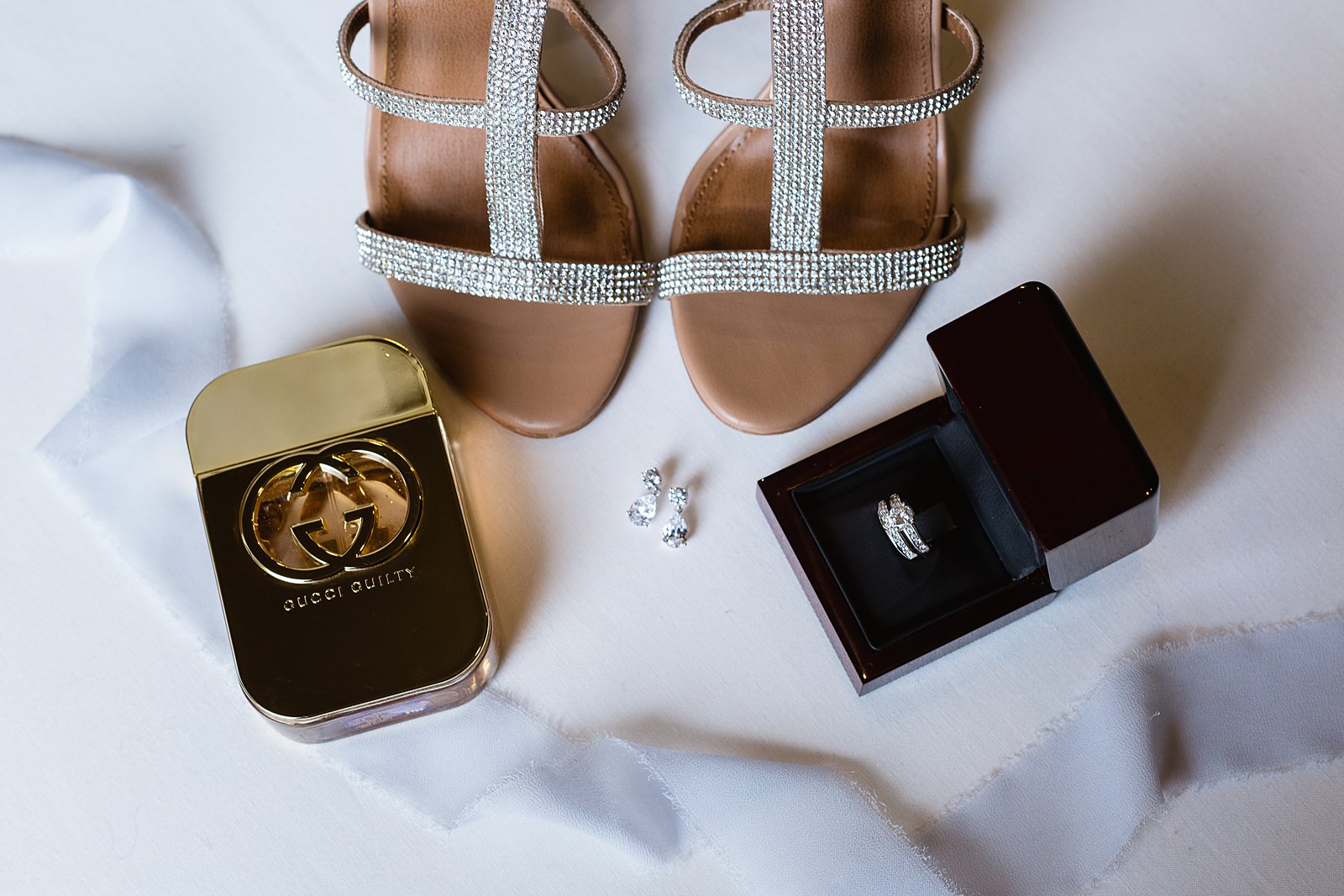 Brides's wedding day details of sparkly shoes, gucci guilty perfume, earrings, and wedding ring by PMA Photography.