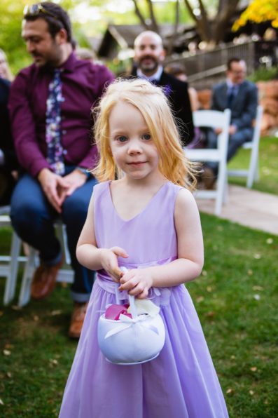 Flower girl walking down the aisle by PMA Photography.