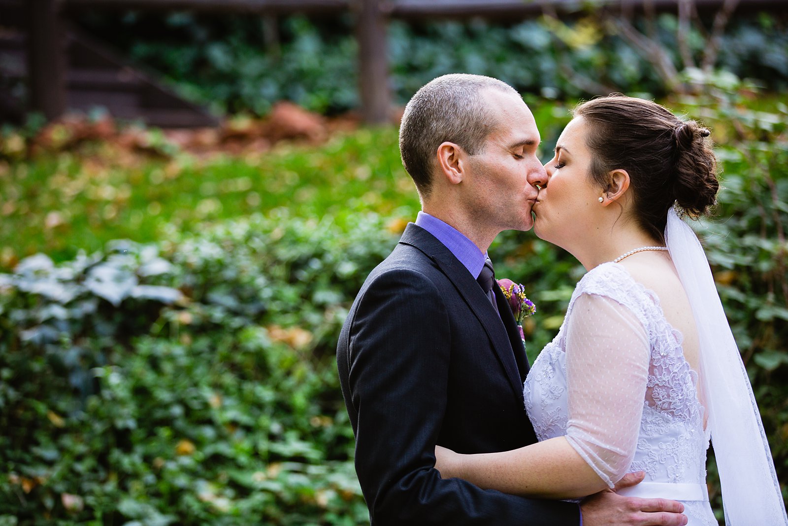 Bride and groom share a kiss during their L'Auberge de Sedona wedding by Sedona wedding photographer PMA Photography.