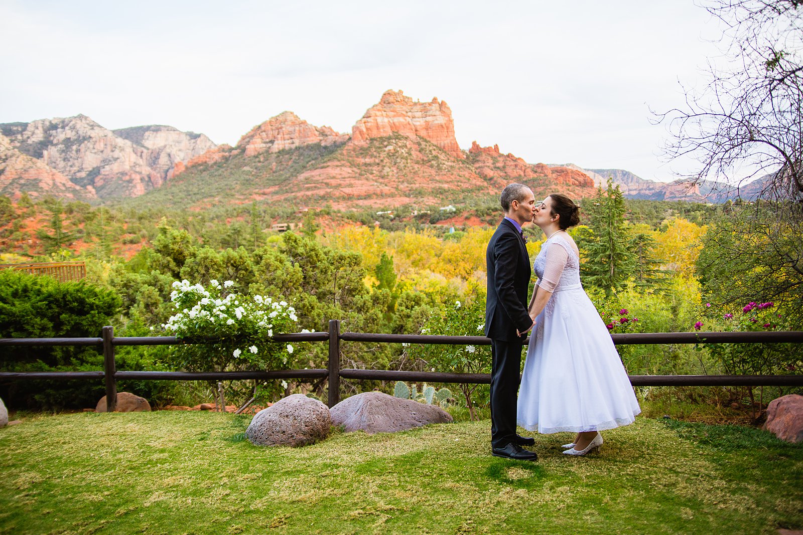 Bride and groom share a kiss during their L'Auberge de Sedona wedding by Arizona wedding photographer PMA Photography.