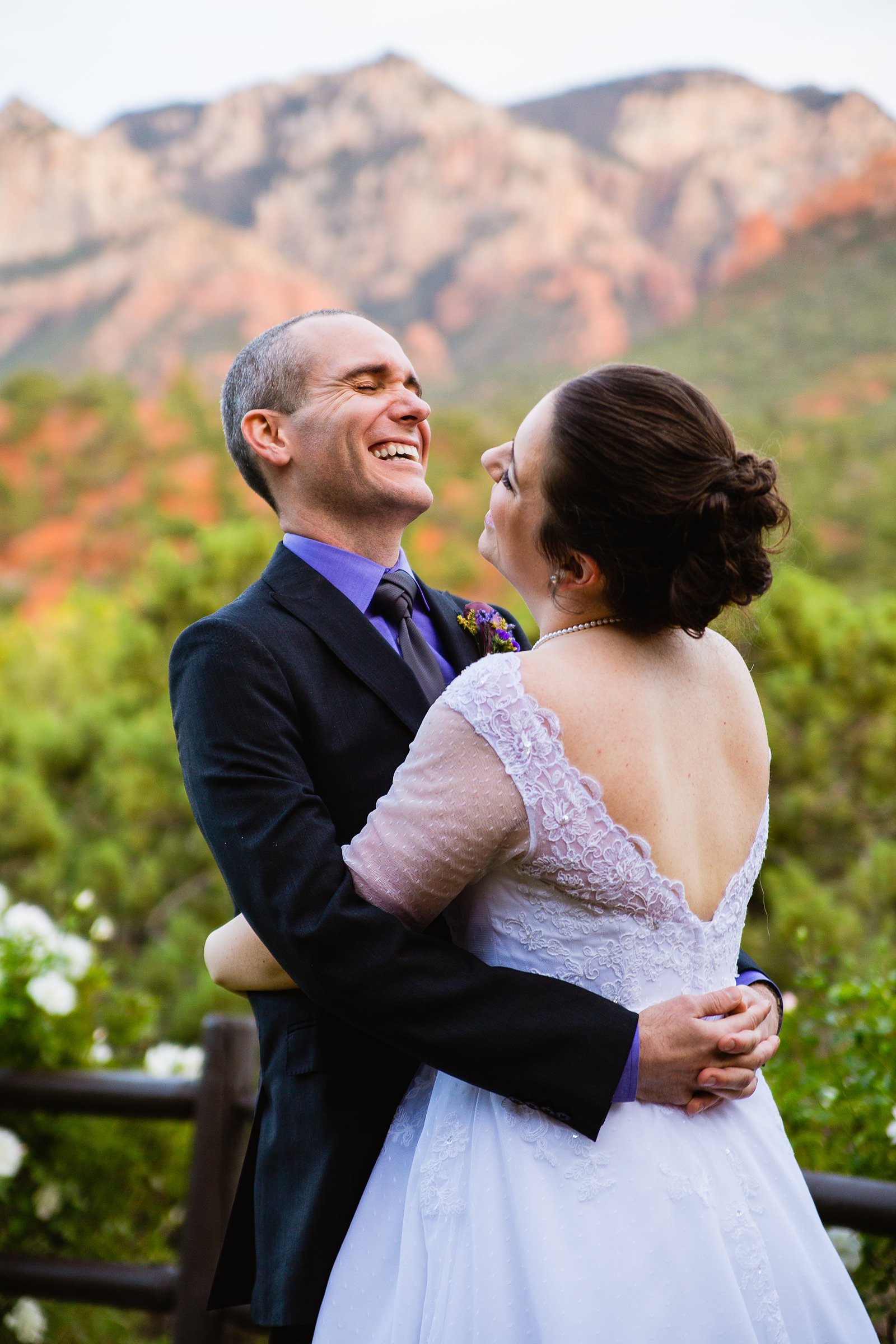 Bride and groom laughing together during their L'Auberge de Sedona wedding by Sedona wedding photographer PMA Photography.