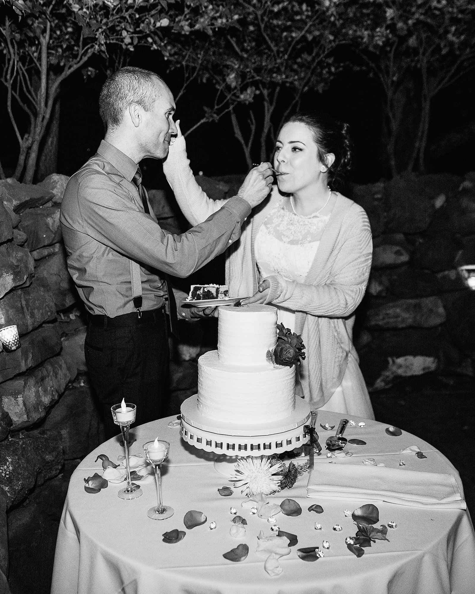 Bride and groom cutting their wedding cake at their L'Auberge de Sedona wedding reception by Arizona wedding photographer PMA Photography.