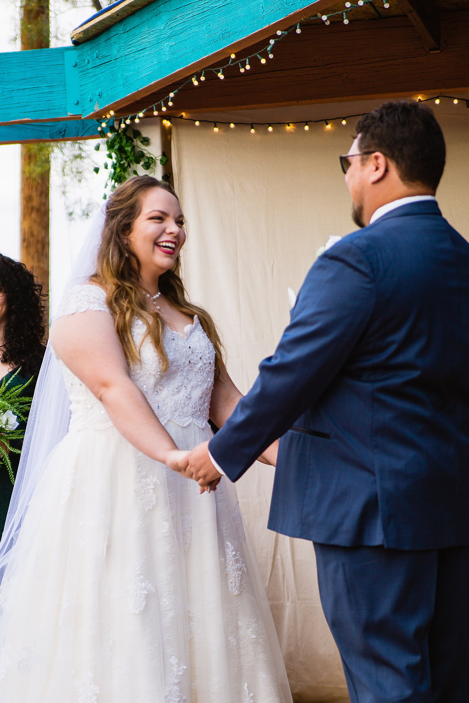 Bride laughing with her groom during their wedding ceremony at Backyard by Casa Grande wedding photographer PMA Photography.