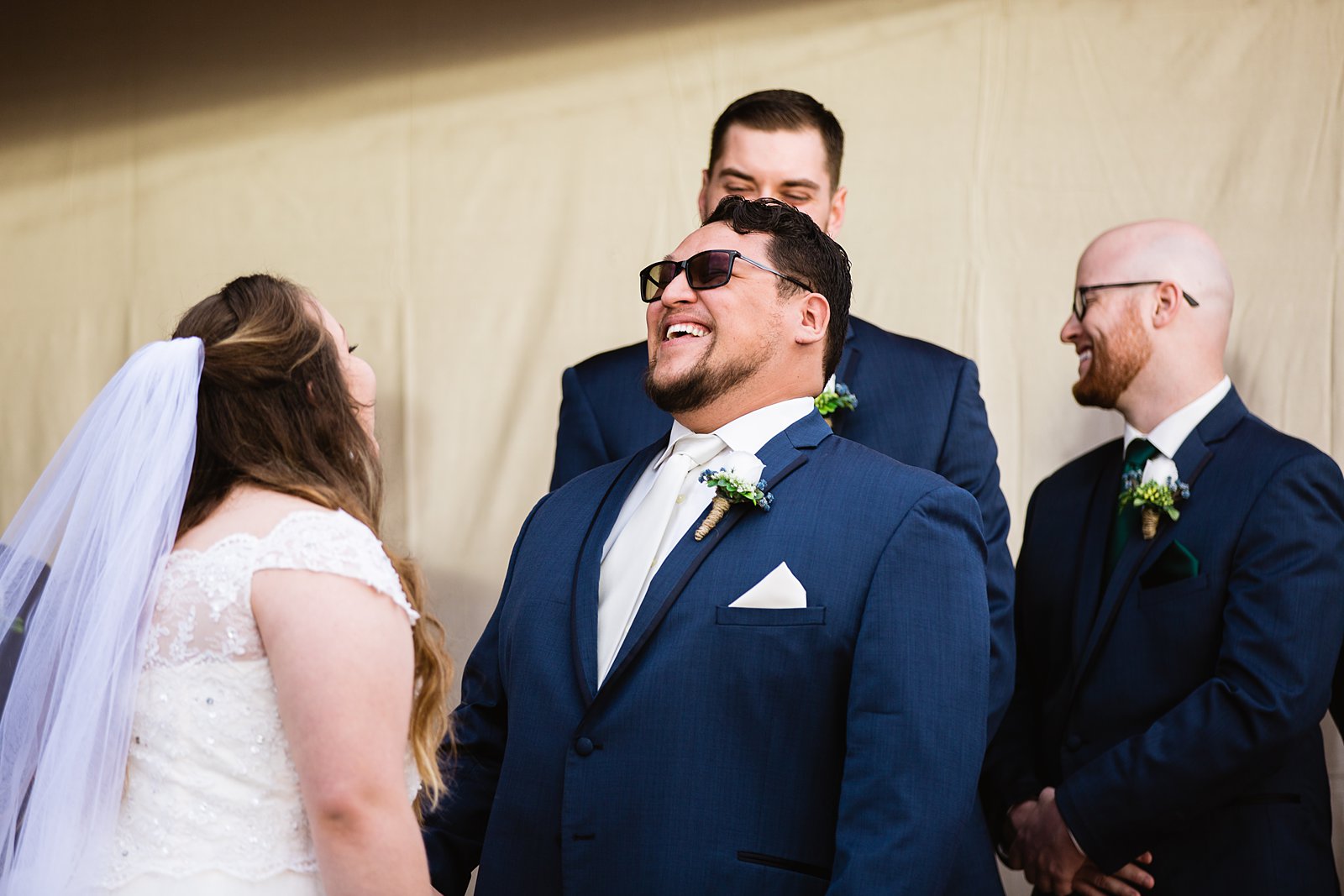 Groom laughing with his bride during their wedding ceremony at Backyard by Casa Grande wedding photographer PMA Photography.