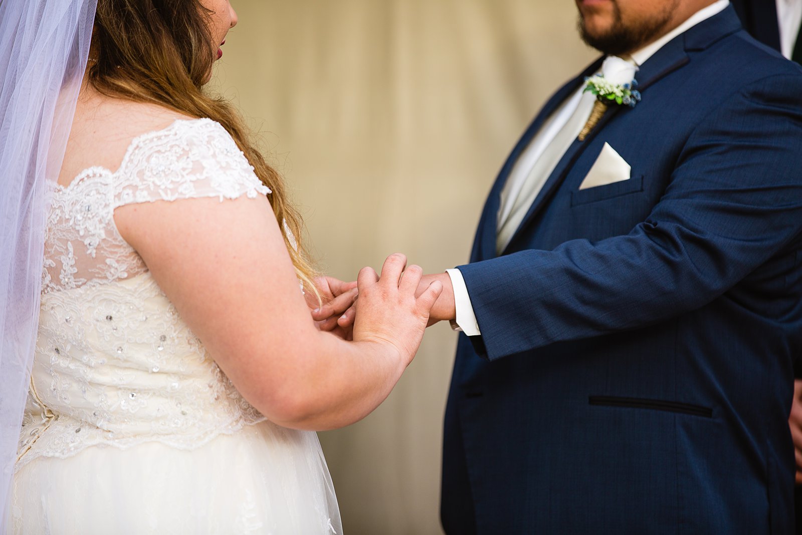 Bride and Groom exchange rings during their wedding ceremony at Backyard by Arizona wedding photographer PMA Photography.