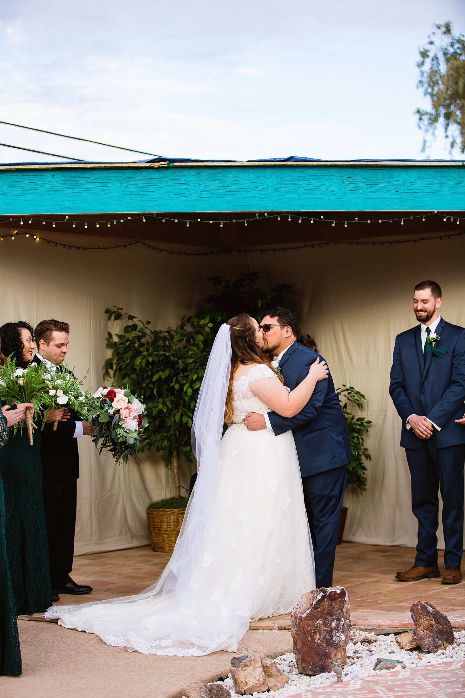 Bride and Groom share their first kiss during their wedding ceremony at Backyard by Arizona wedding photographer PMA Photography.