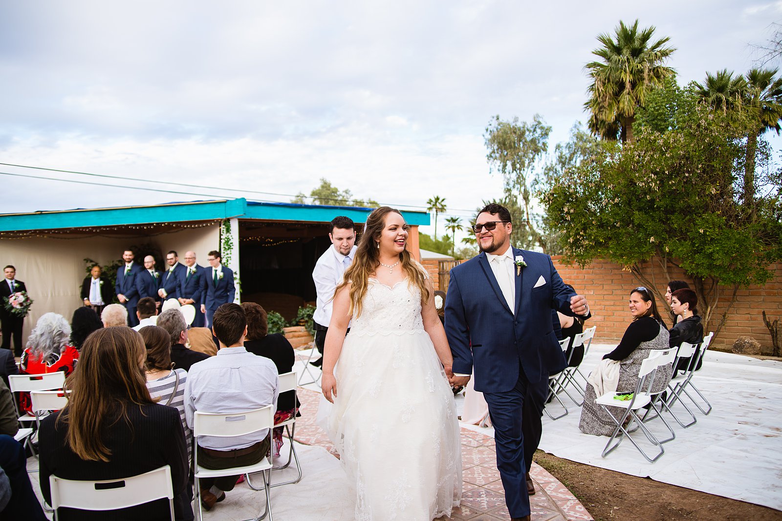 Bride and Groom walking down the aisle together as newlyweds by PMA Photography.