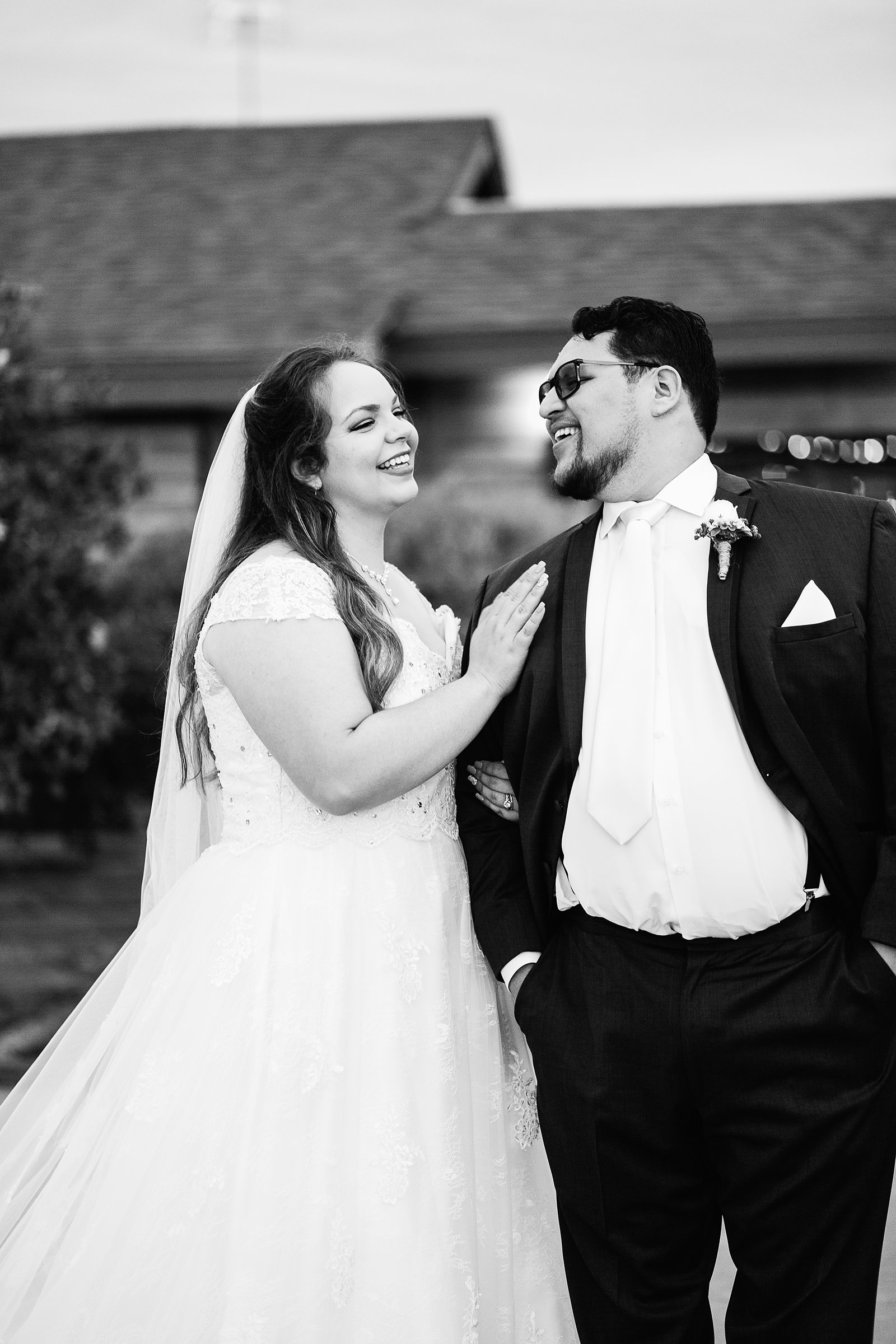 Bride and Groom laughing together during their Backyard wedding by Arizona wedding photographer PMA Photography.