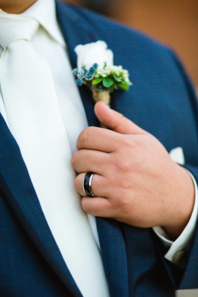 Groom's black and silver wedding band on his navy suit by PMA Photography.
