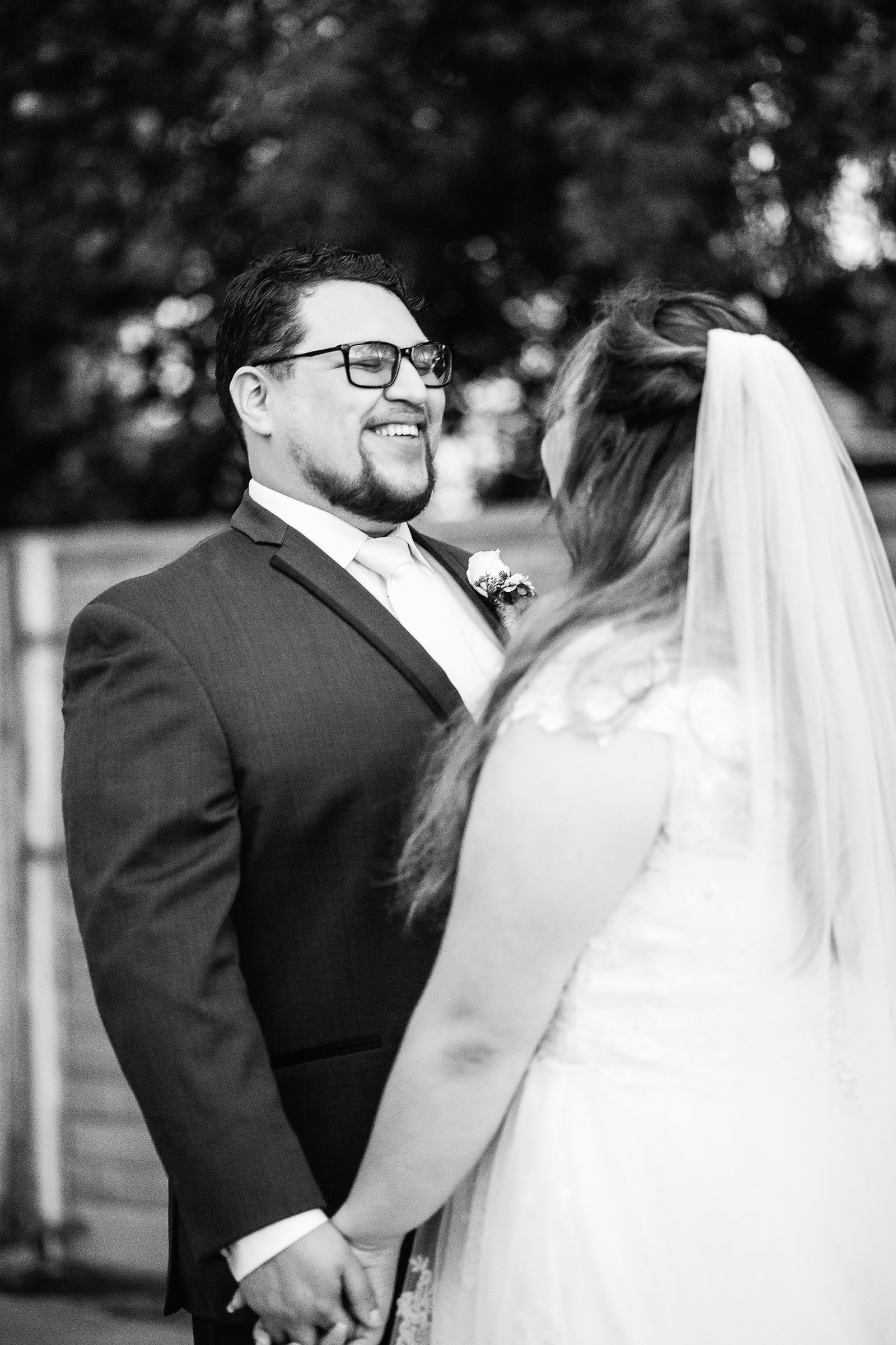 Bride and Groom laughing together during their Backyard wedding by Casa Grande wedding photographer PMA Photography.