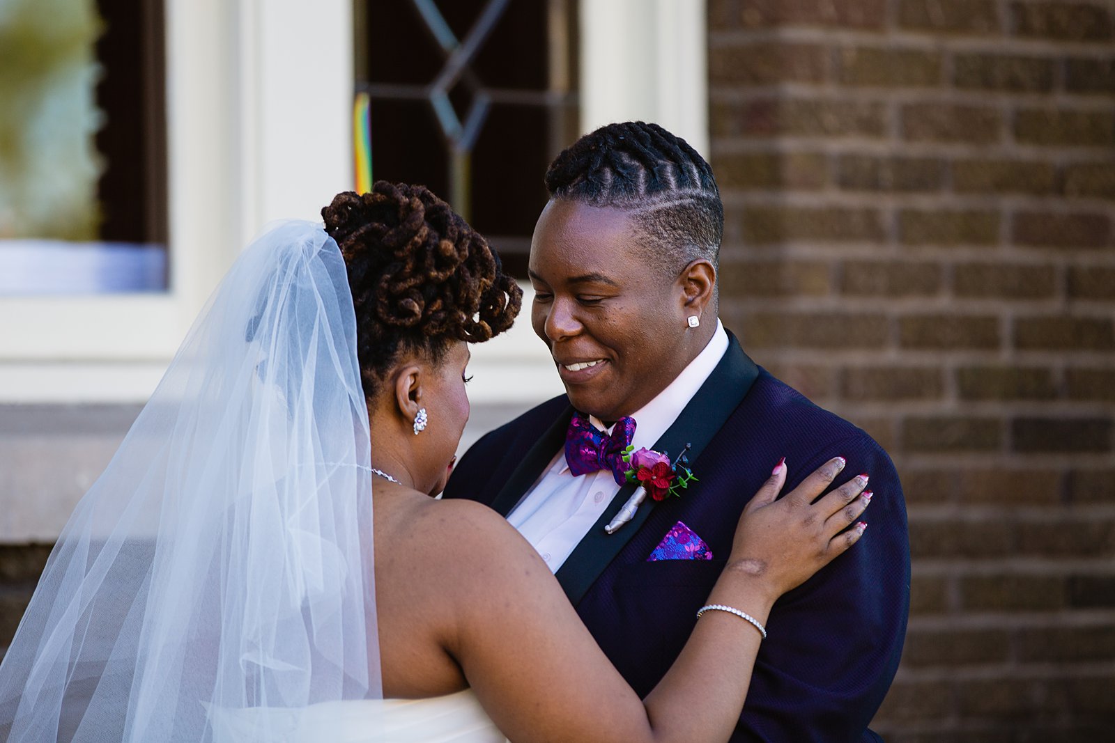 Same sex couple share an intimate moment during their first look at Ellis-Shackelford House by Arizona wedding photographer PMA Photography.
