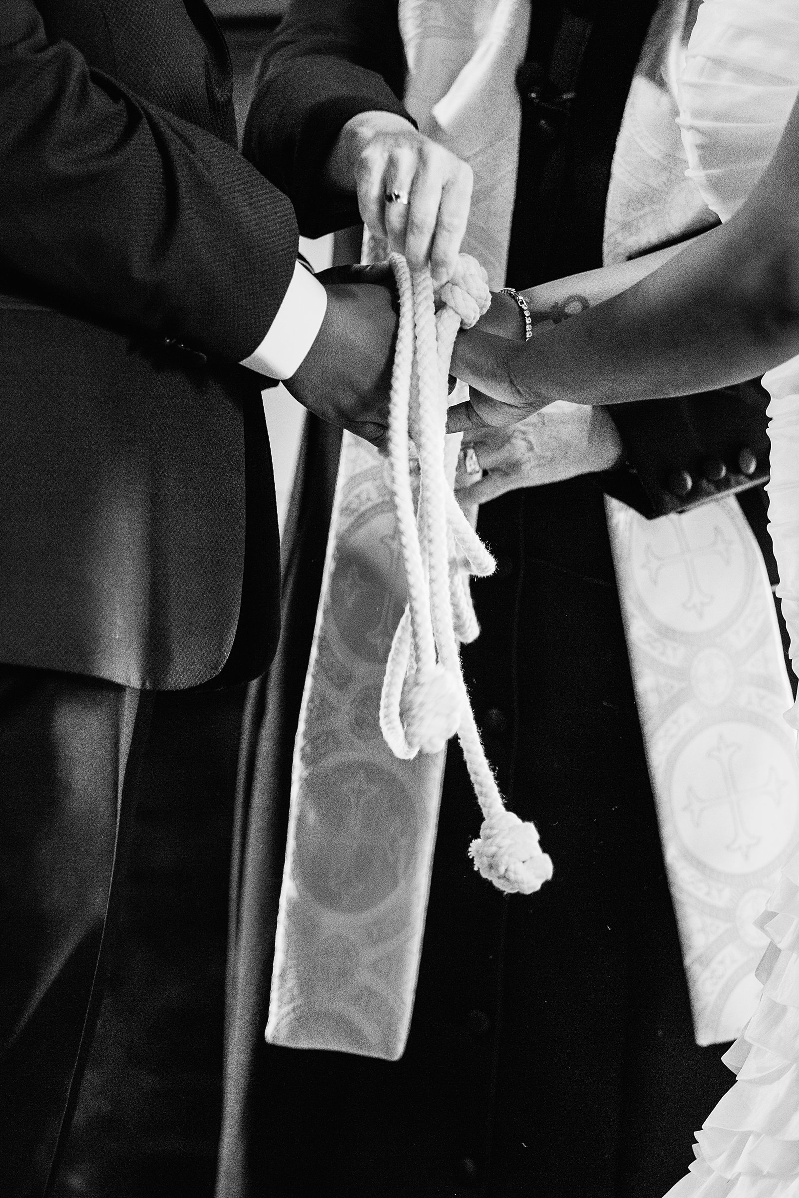 Same sex couple do a hand fasting unity ceremony during their wedding ceremony at Ellis-Shackelford House by Arizona wedding photographer PMA Photography.