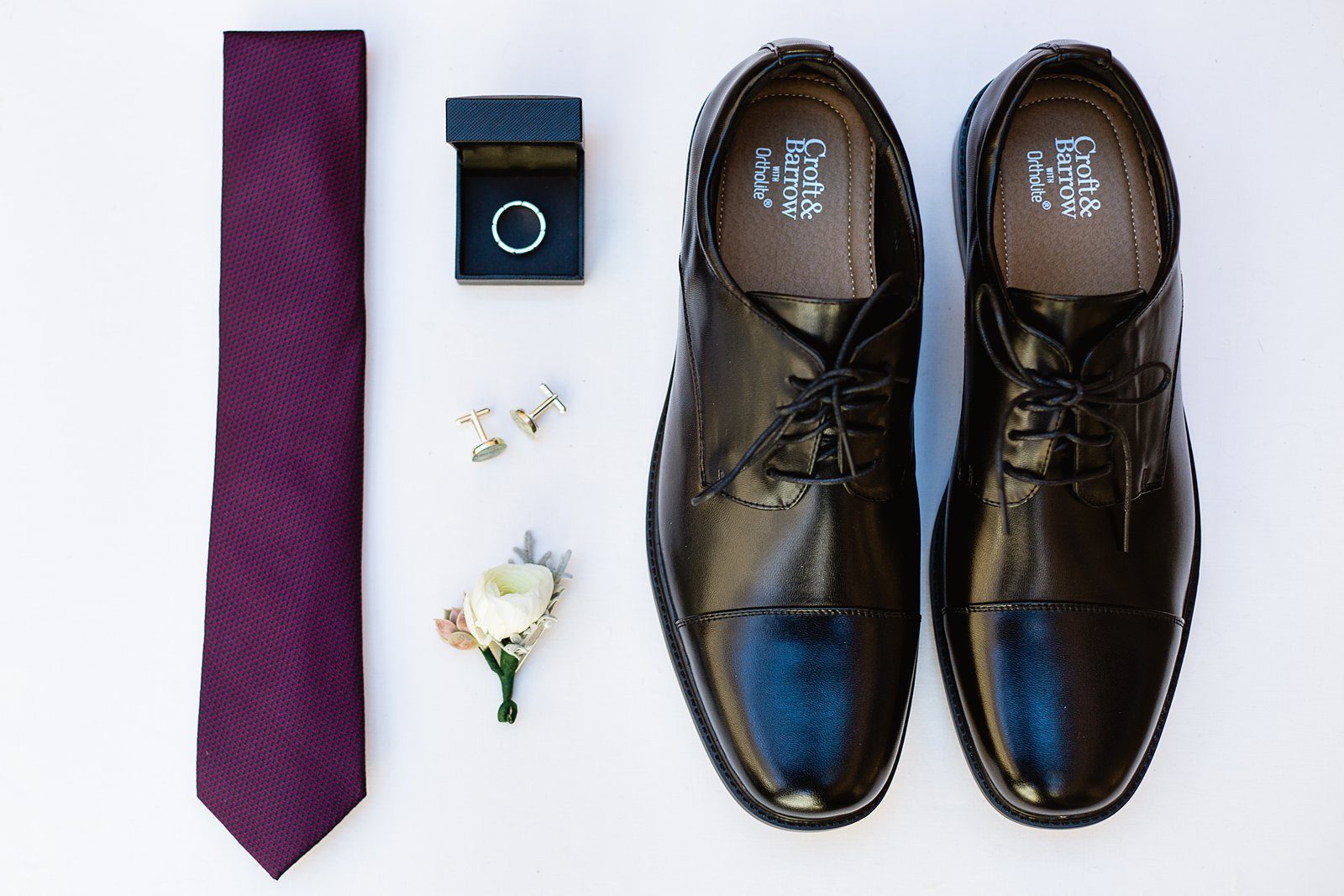 Groom's wedding day details of purple tie, cufflinks, ring and black shoes by PMA Photography.