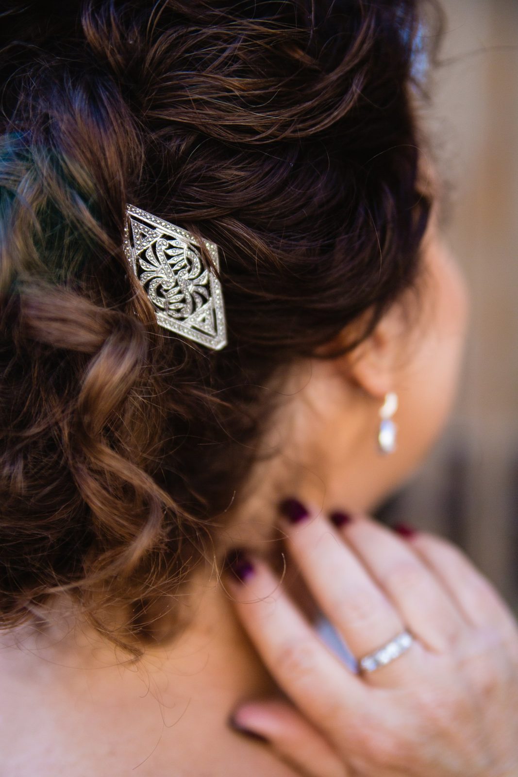 Bride wearing her grandmother's hair clip in her hair on her wedding day by PMA Photography.