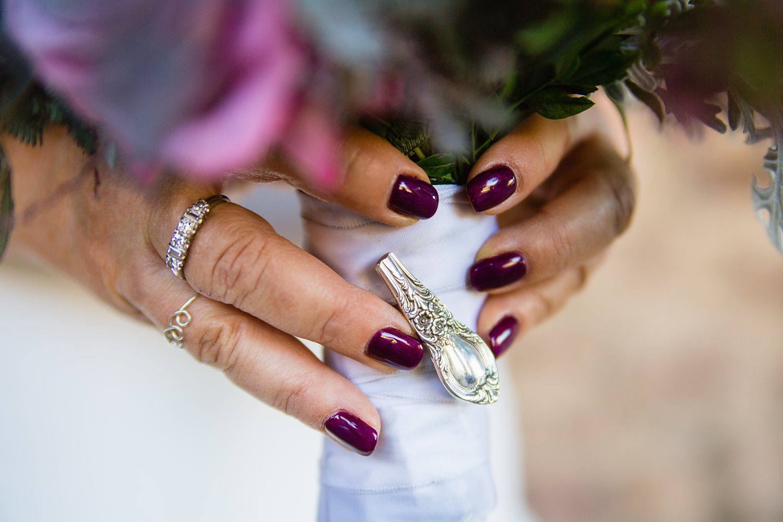 Pin made from the bride's grandmothers antique silverware set on her bouquet by PMA Photography.