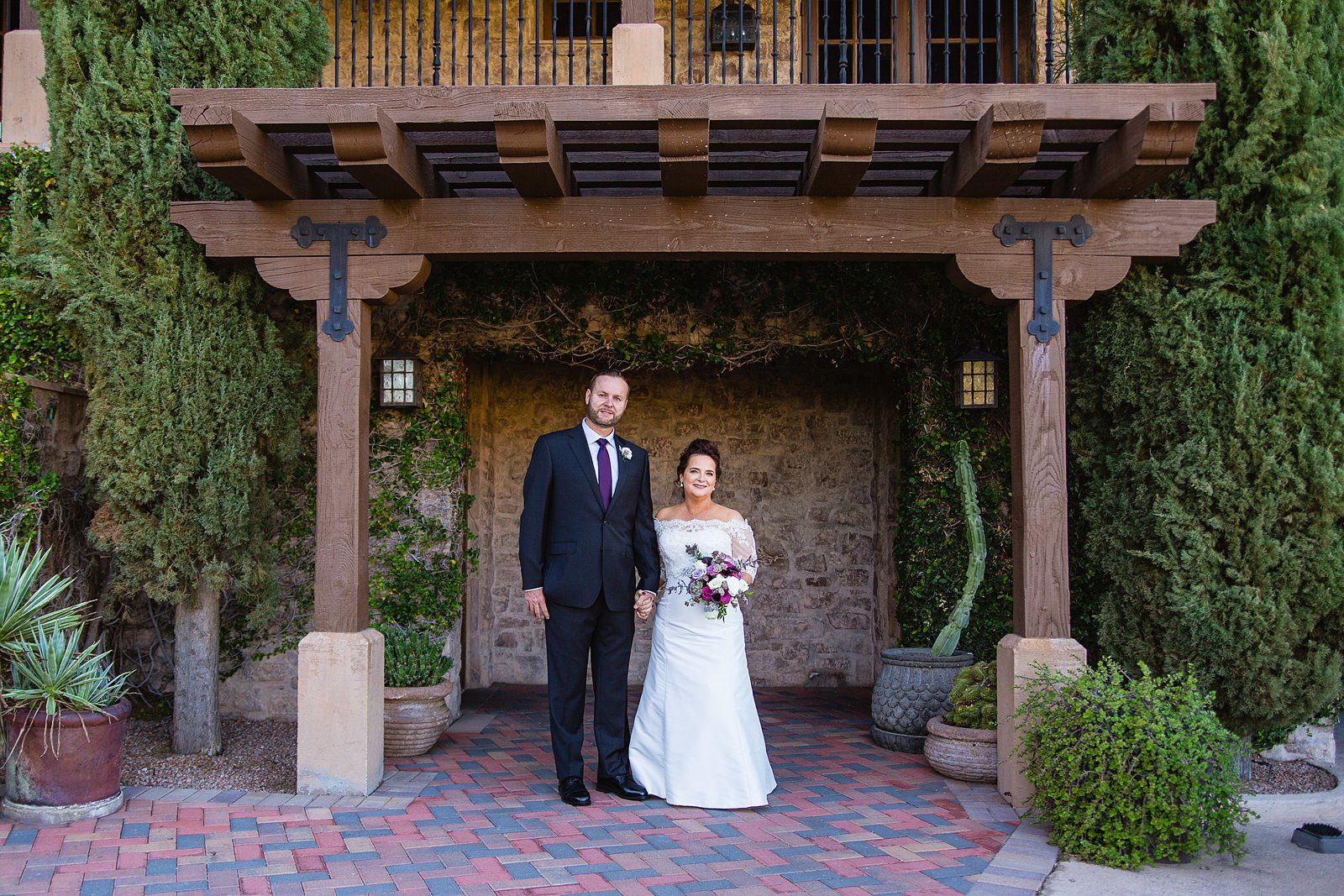 Bride and groom pose for their Superstition Mountain Clubhouse wedding by Mesa wedding photographer PMA Photography.