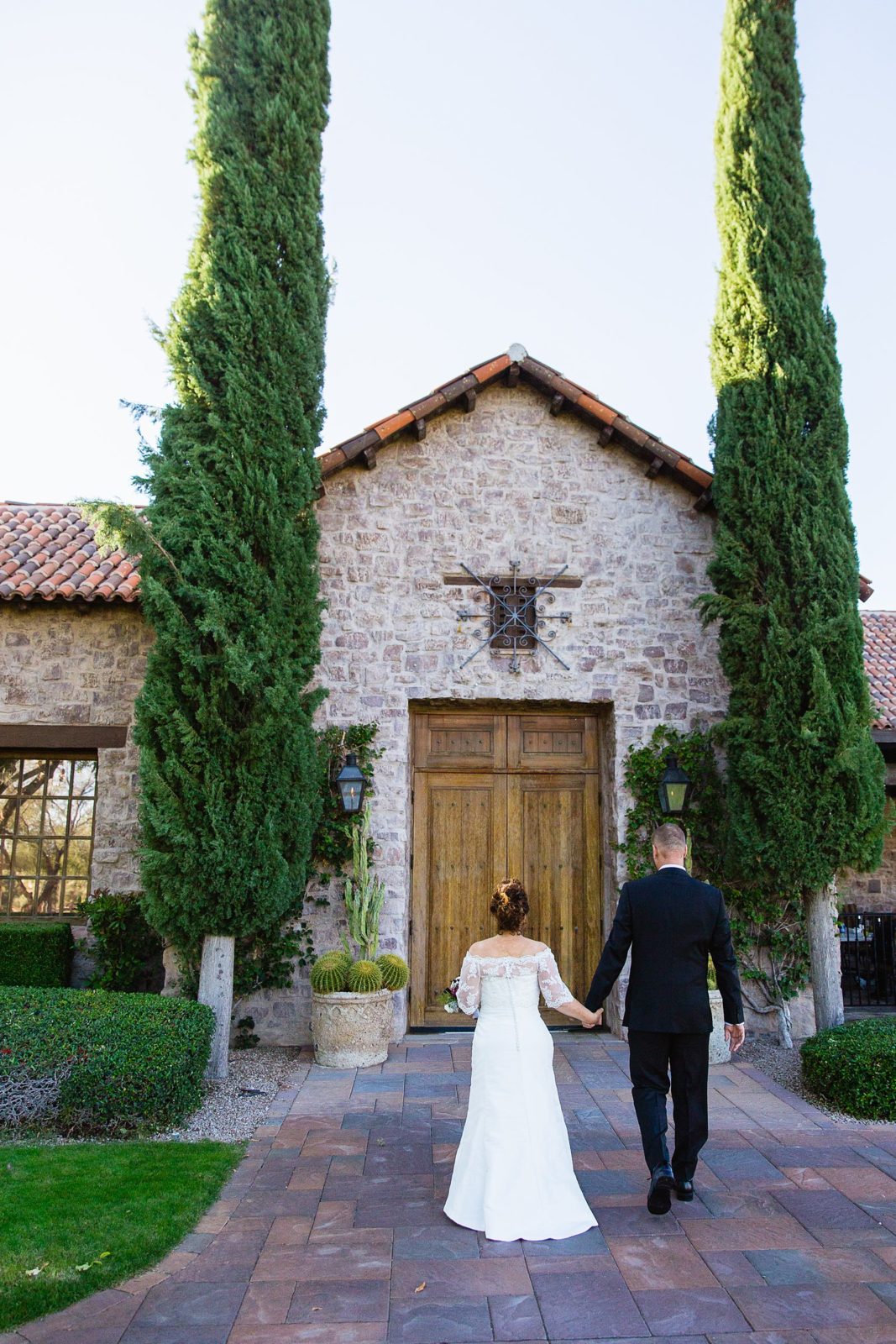 Bride and groom walking together during their Superstition Mountain Clubhouse wedding by Mesa wedding photographer PMA Photography.