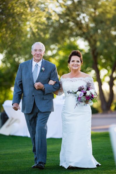 Bride walking down aisle during Superstition Mountain Clubhouse wedding ceremony by Arizona wedding photographer PMA Photography.