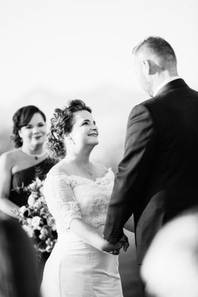 Bride looking at her groom during their wedding ceremony at Superstition Mountain Clubhouse by Mesa wedding photographer PMA Photography.