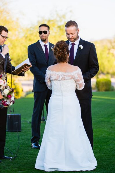 Groom looking at his bride during their wedding ceremony at Superstition Mountain Clubhouse by Mesa wedding photographer PMA Photography.