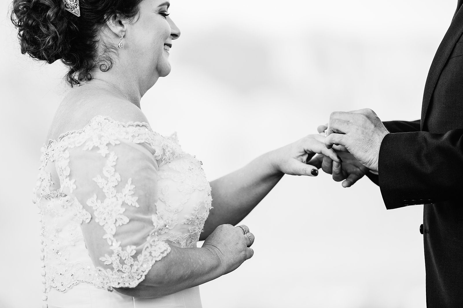 Bride and groom exchange rings during their wedding ceremony at Superstition Mountain Clubhouse by Arizona wedding photographer PMA Photography.