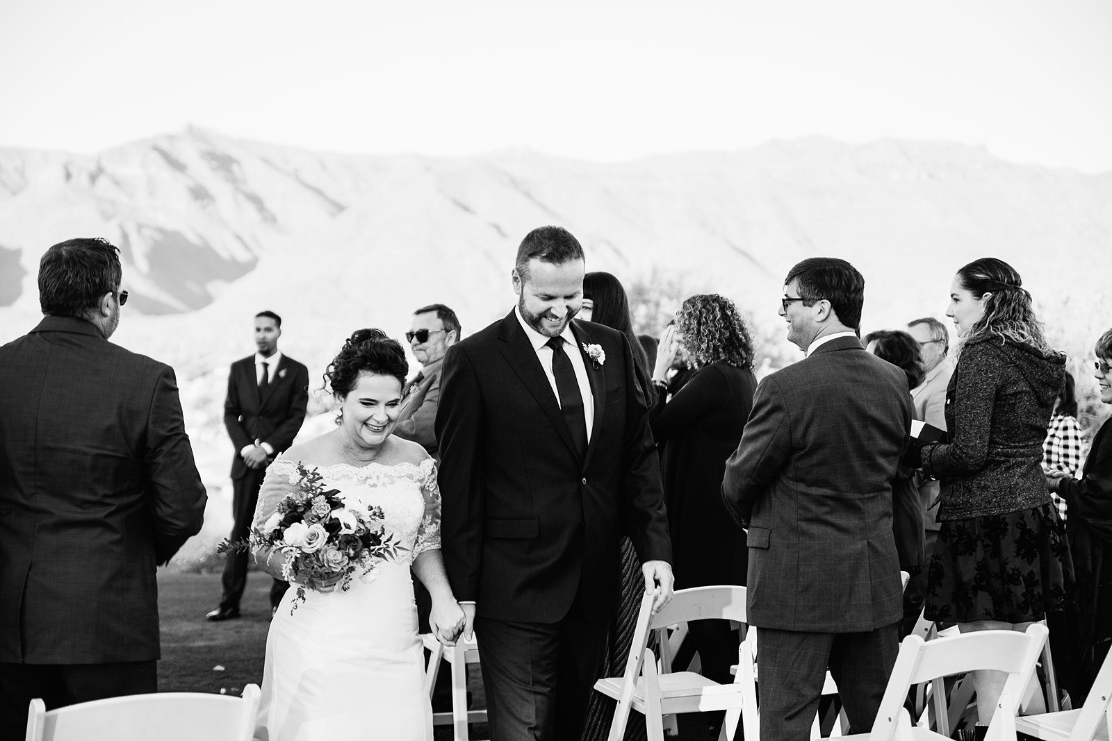 Bride and groom walking down the aisle together as newlyweds by PMA Photography.