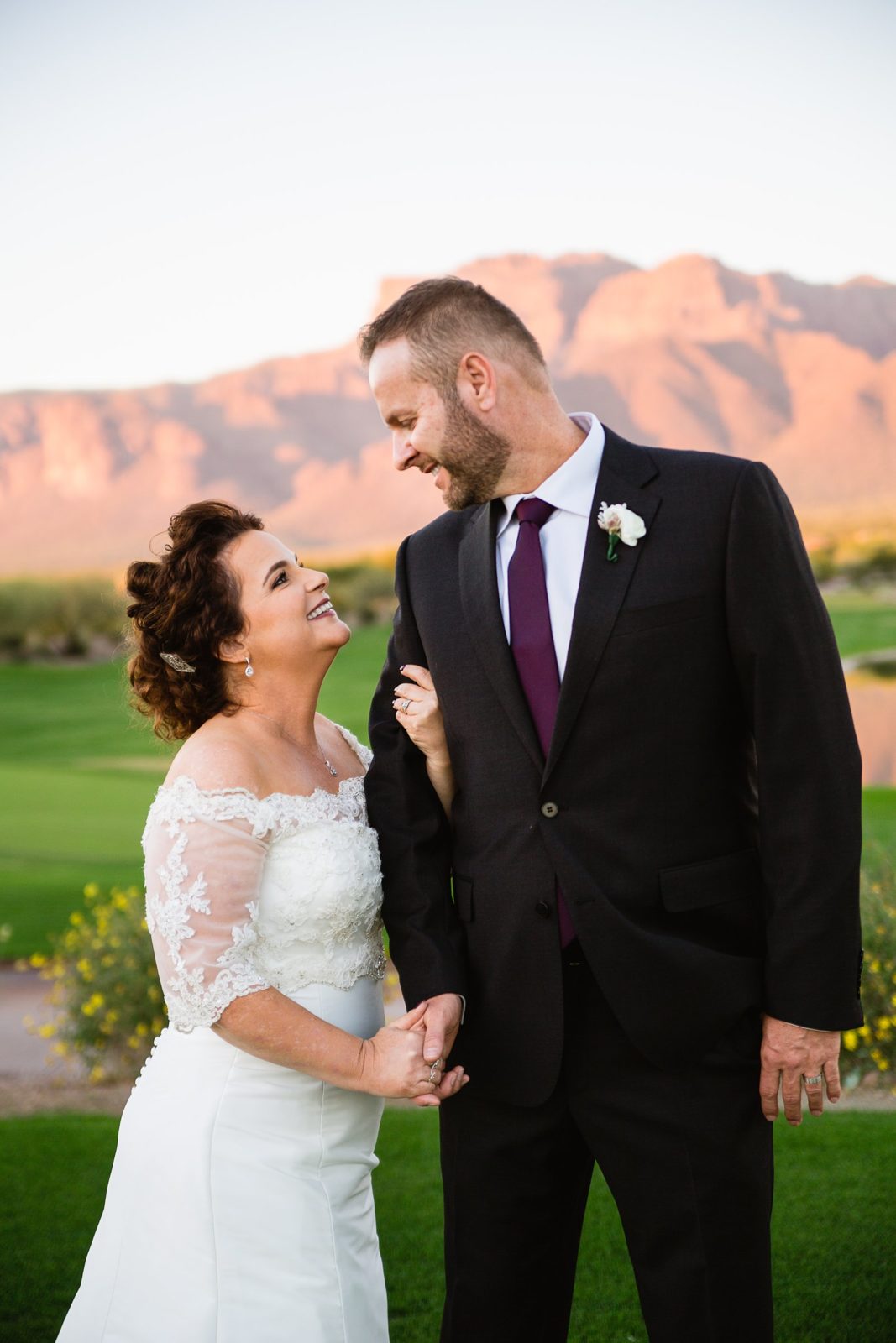 Bride and groom pose for their Superstition Mountain Clubhouse wedding by Mesa wedding photographer PMA Photography.