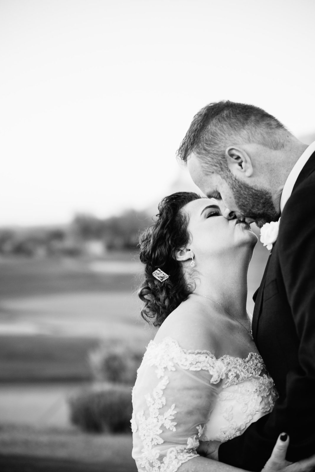 Bride and groom share a kiss during their Superstition Mountain Clubhouse wedding by Mesa wedding photographer PMA Photography.