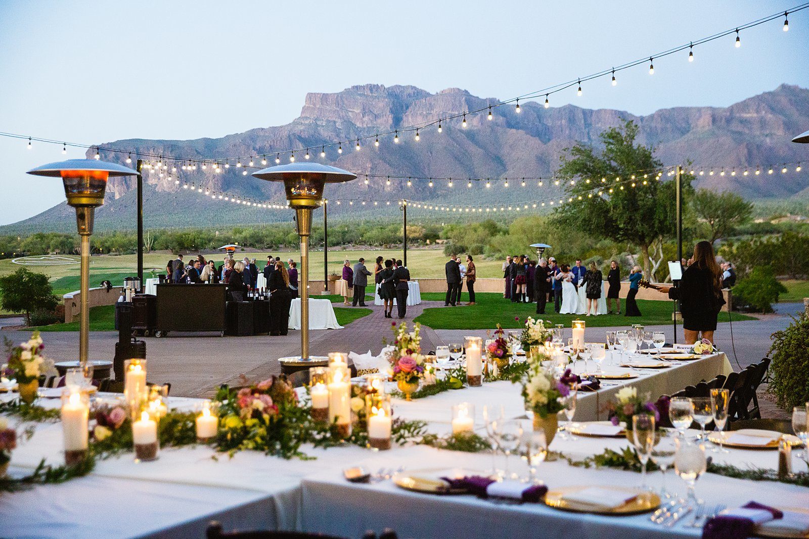 Guests enjoying cocktail hour against the backdrop of the Supersition Mountains by Arizona wedding photographer PMA Photography.
