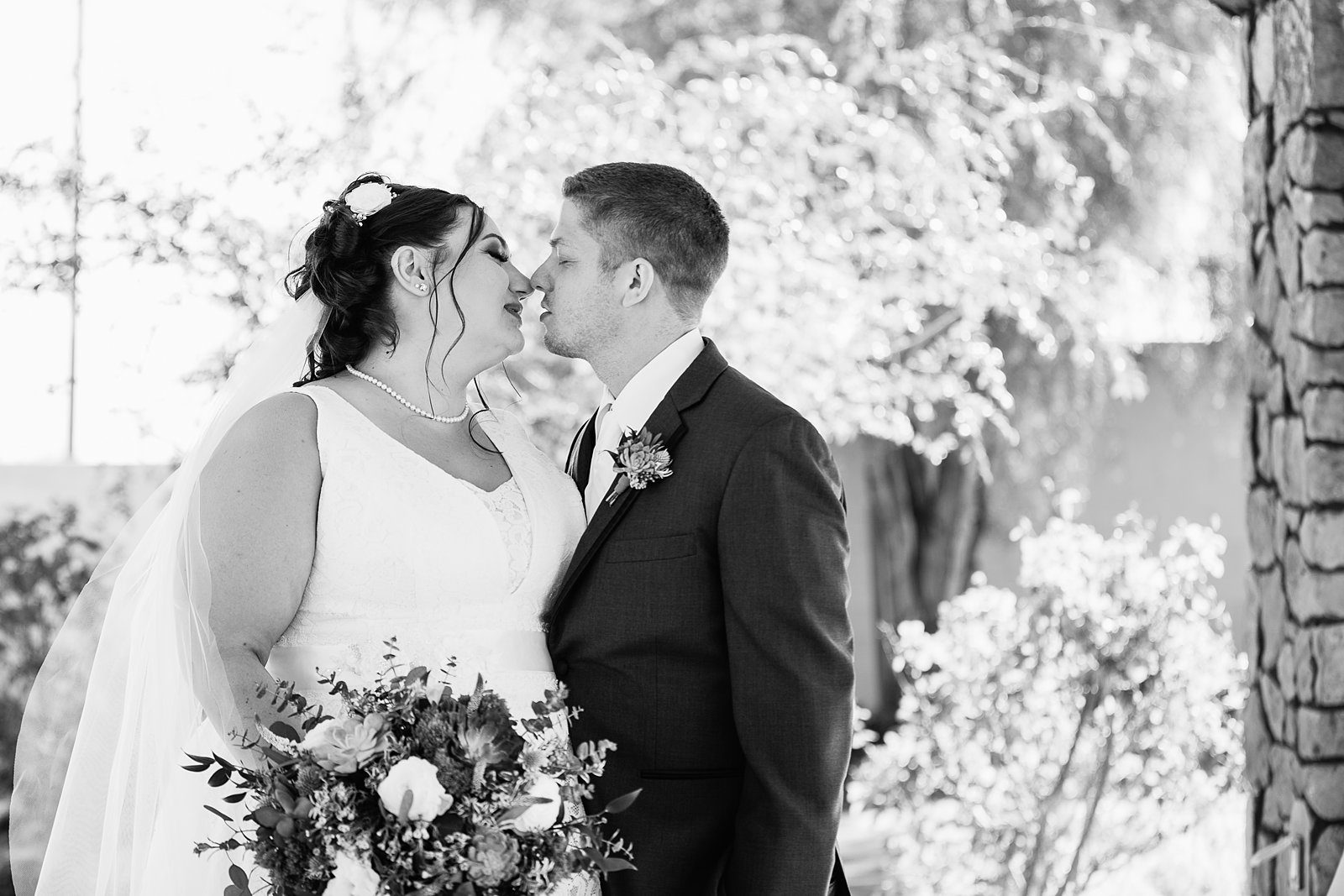 Bride and Groom share a kiss during their Superstition Manor wedding by Mesa wedding photographer PMA Photography.