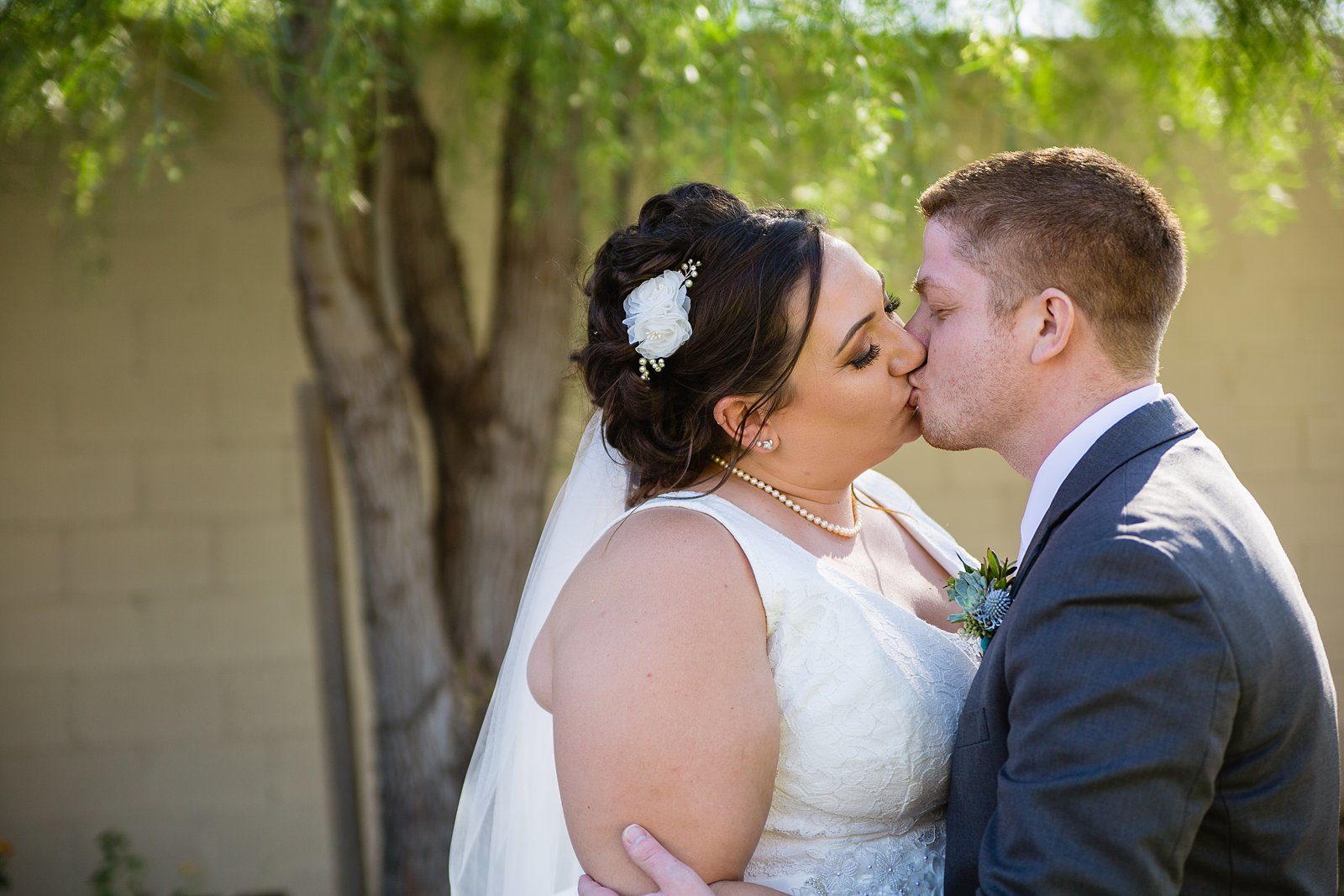 Bride and Groom share a kiss during their Superstition Manor wedding by Arizona wedding photographer PMA Photography.