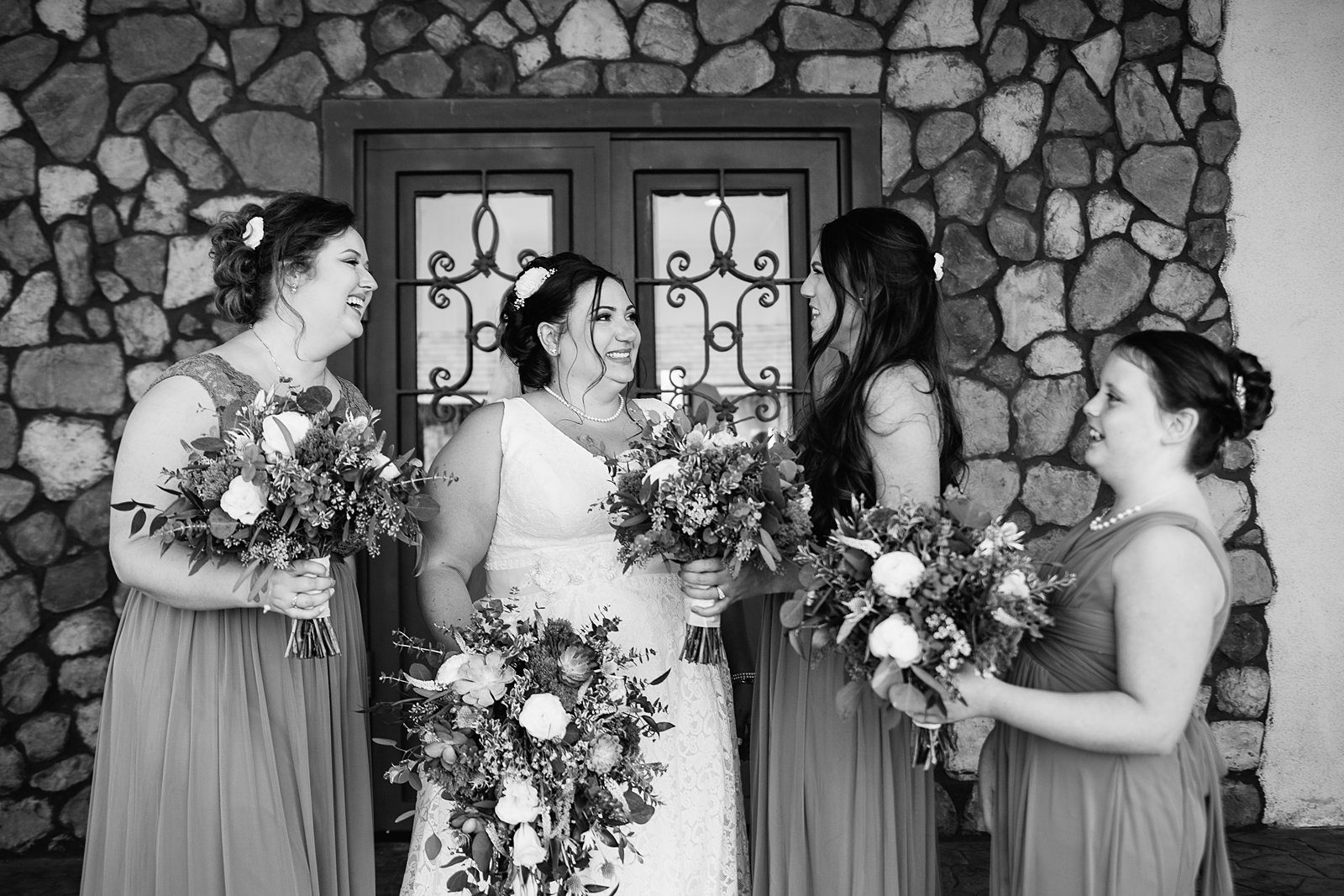 Bride and bridesmaids laughing together at Superstition Manor wedding by Mesa wedding photographer PMA Photography.