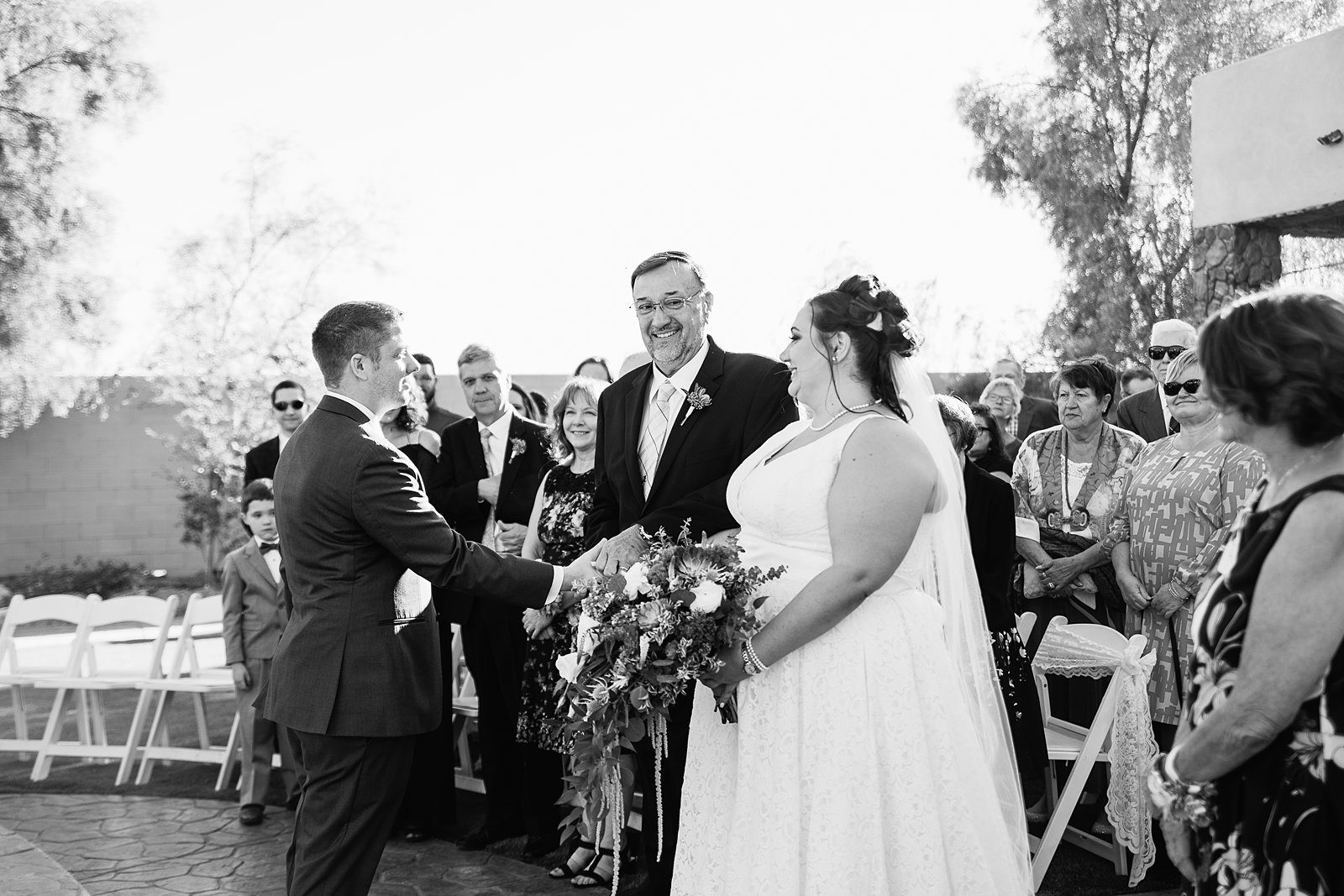 Bride walking down aisle during Superstition Manor wedding ceremony by Arizona wedding photographer PMA Photography.