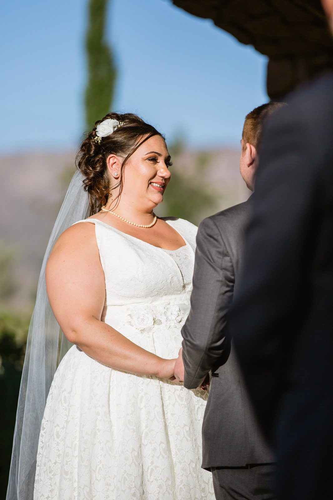 Bride looking at her groom during their wedding ceremony at Superstition Manor by Mesa wedding photographer PMA Photography.