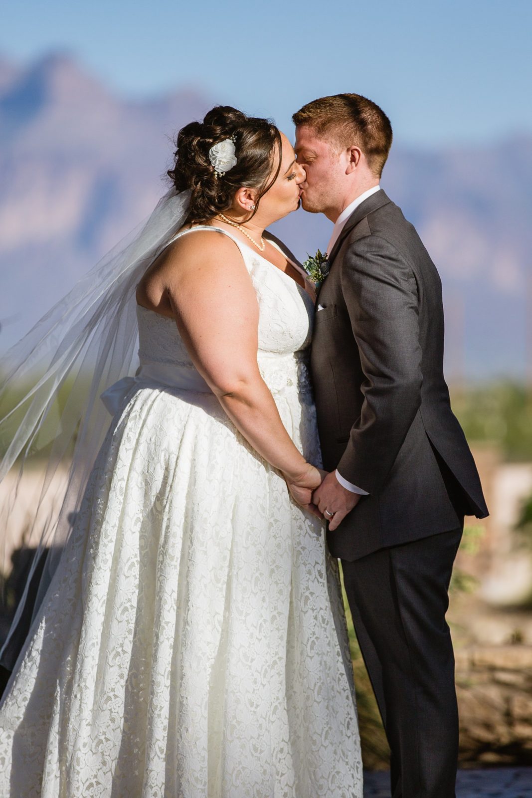 Bride and Groom share their first kiss during their wedding ceremony at Superstition Manor by Arizona wedding photographer PMA Photography.