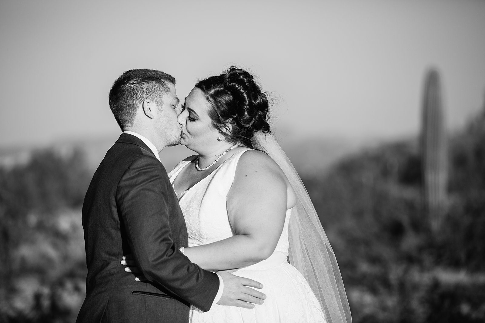 Bride and Groom share a kiss during their Superstition Manor wedding by Arizona wedding photographer PMA Photography.