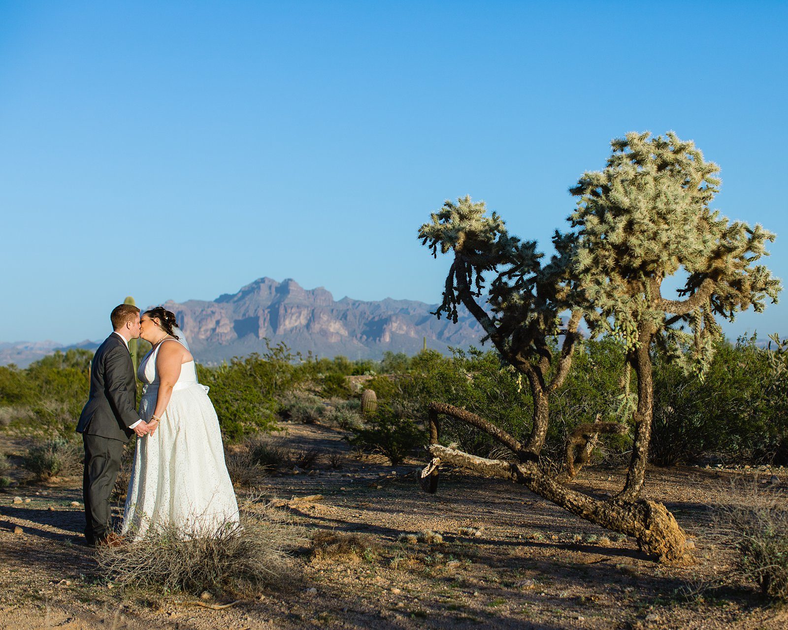 Bride and Groom share a kiss during their Superstiton Manor wedding by Arizona wedding photographer PMA Photography.